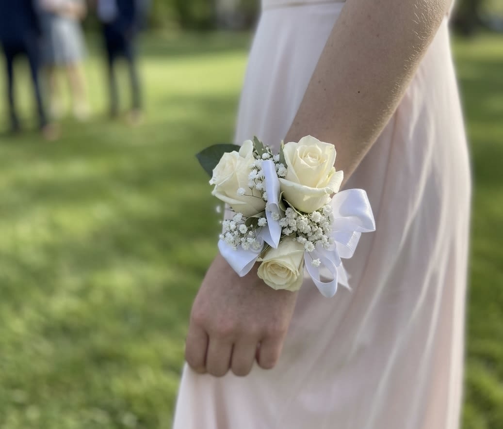 White Rose &amp; Baby's Breath Wrist Corsage - An elegant and classic wrist corsage featuring 3 premium white spray roses nestled in a delicate bed of airy white baby's breath. Beautifully finished with a soft white satin ribbon, this charming accessory adds a touch of timeless grace. Perfect for prom, weddings, anniversaries, or any formal celebration.