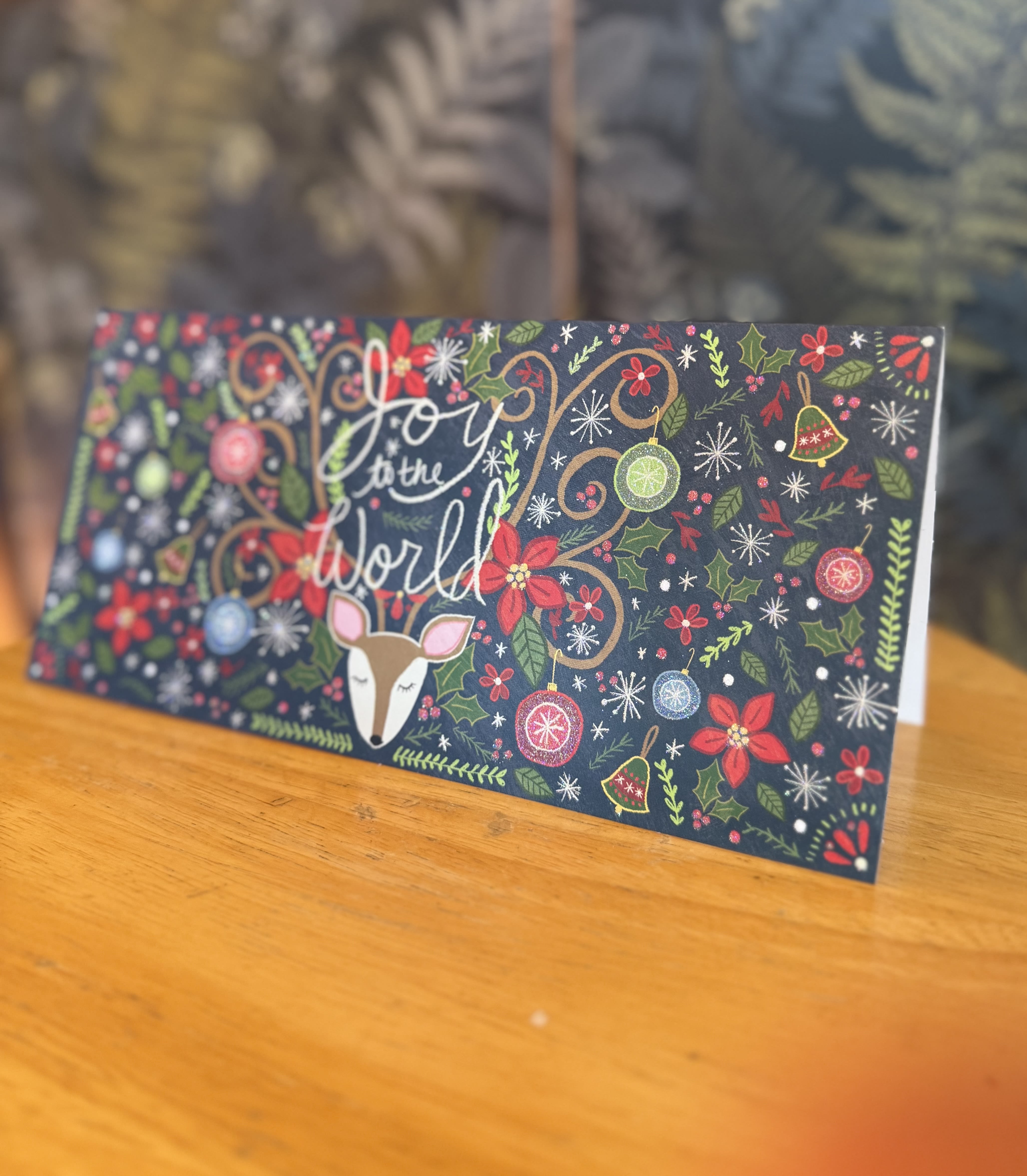 Holiday card with a deer and "Joy to the World" text
