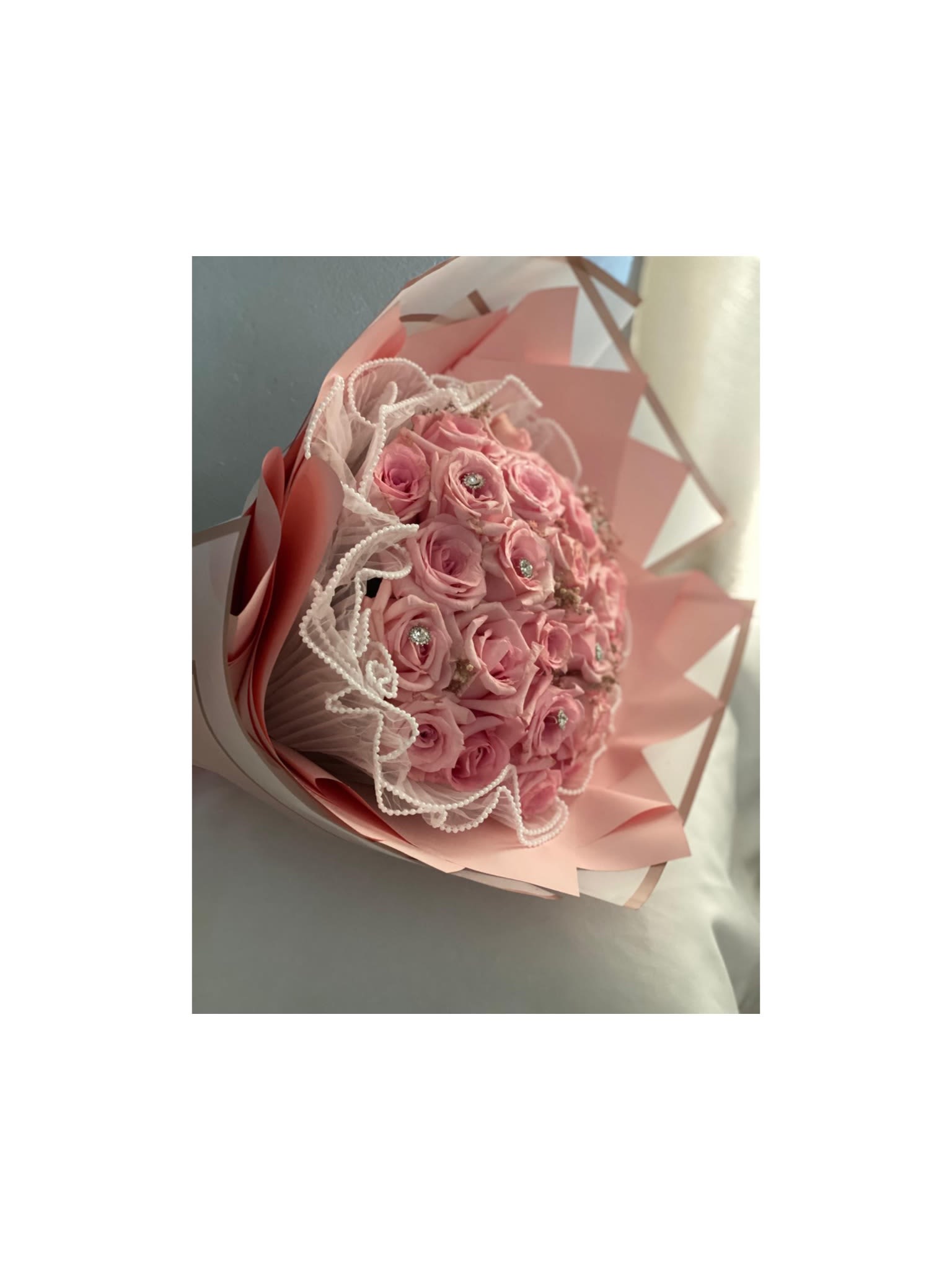 Pink rose bouquet wrapped in pastel paper with lace trim