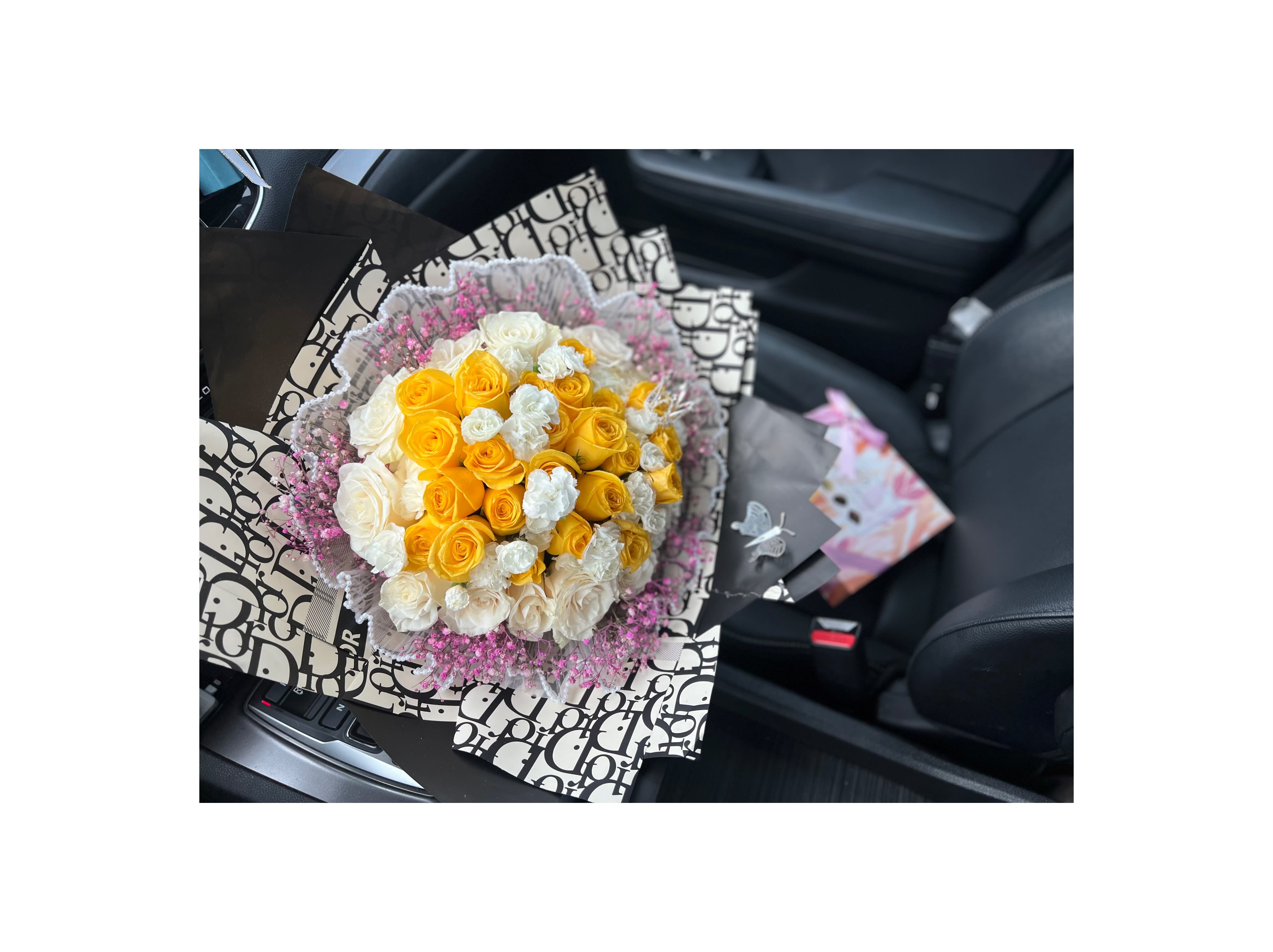 Bouquet of yellow and white roses wrapped in patterned paper