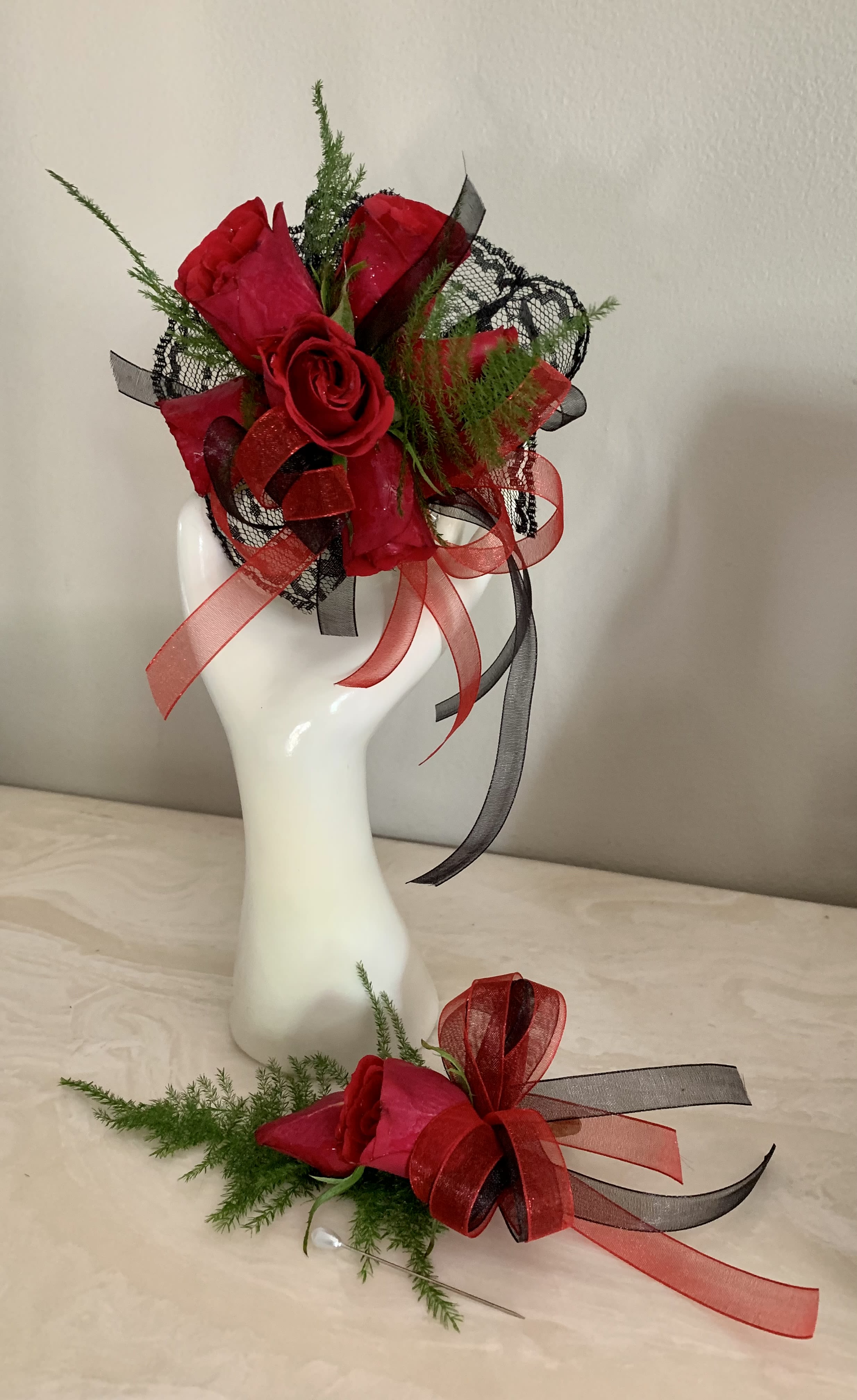 Red rose corsage and boutonniere with black and red ribbon accents