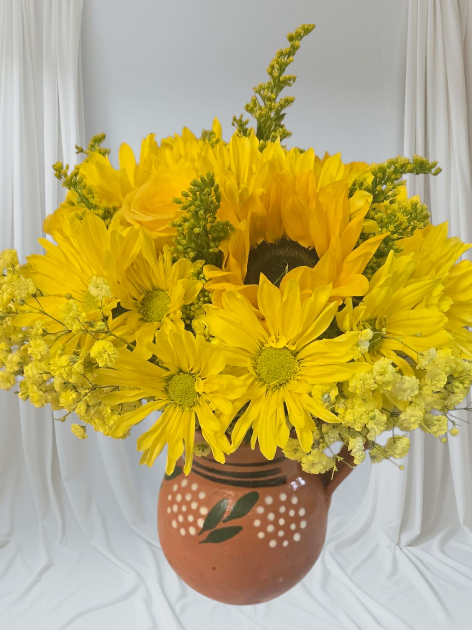 Yellow daisy bouquet in a painted terracotta vase