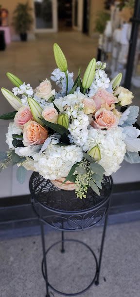 Peachy dreams - Rounded bouquet of peach roses, white hydrangeas and lily buds in a basket.