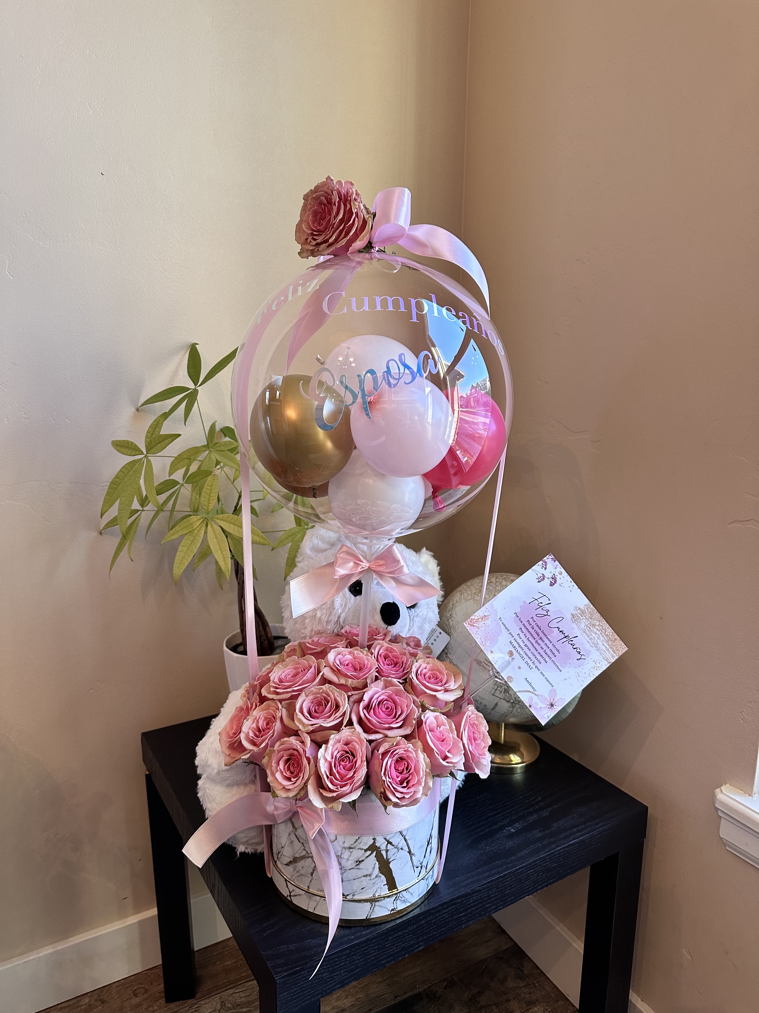 Pink rose arrangement with balloons and a teddy bear in a gift box