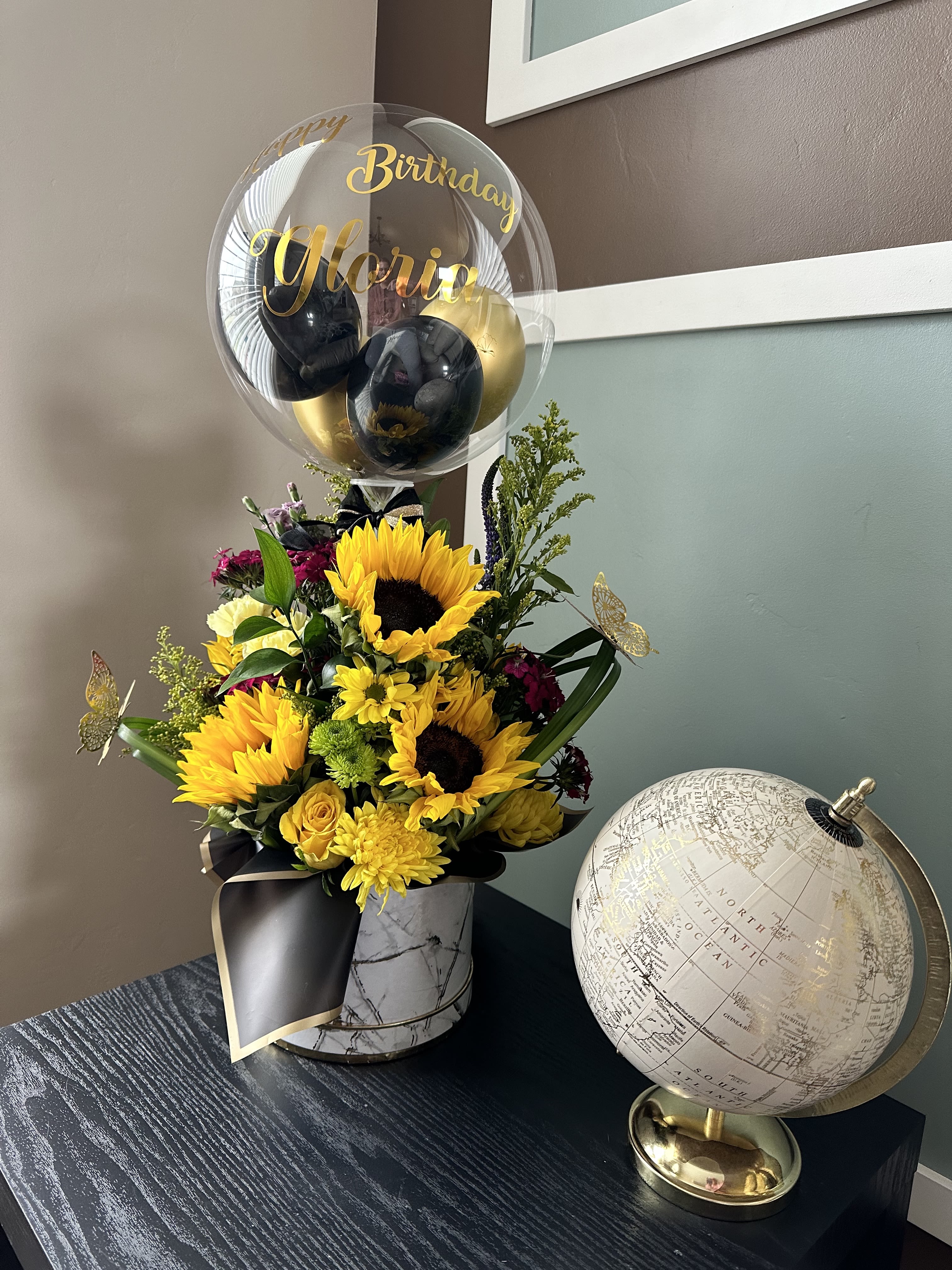 Sunflower bouquet with a birthday balloon in a marble vase