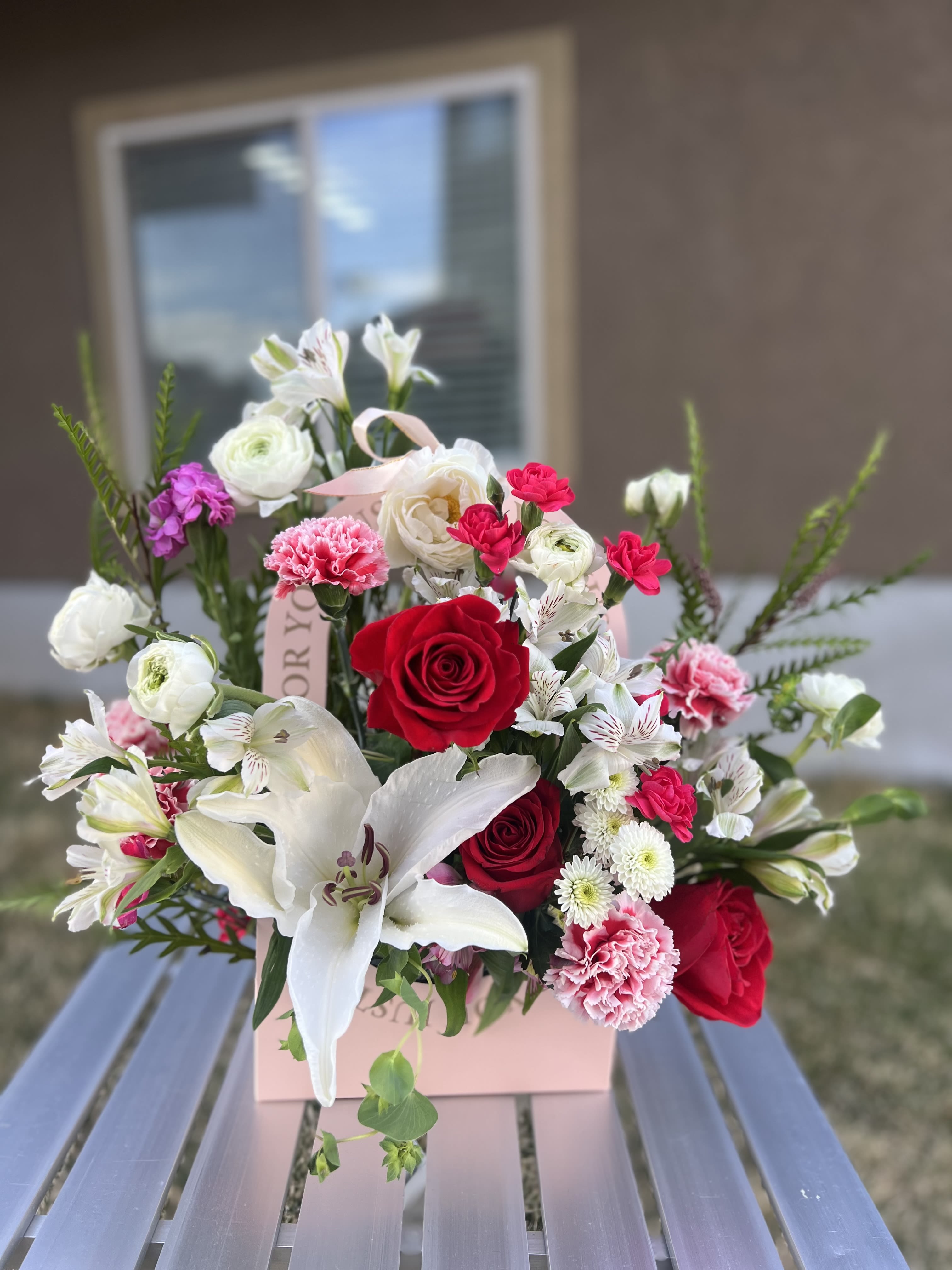 Bouquet of red and white flowers in a pink gift box