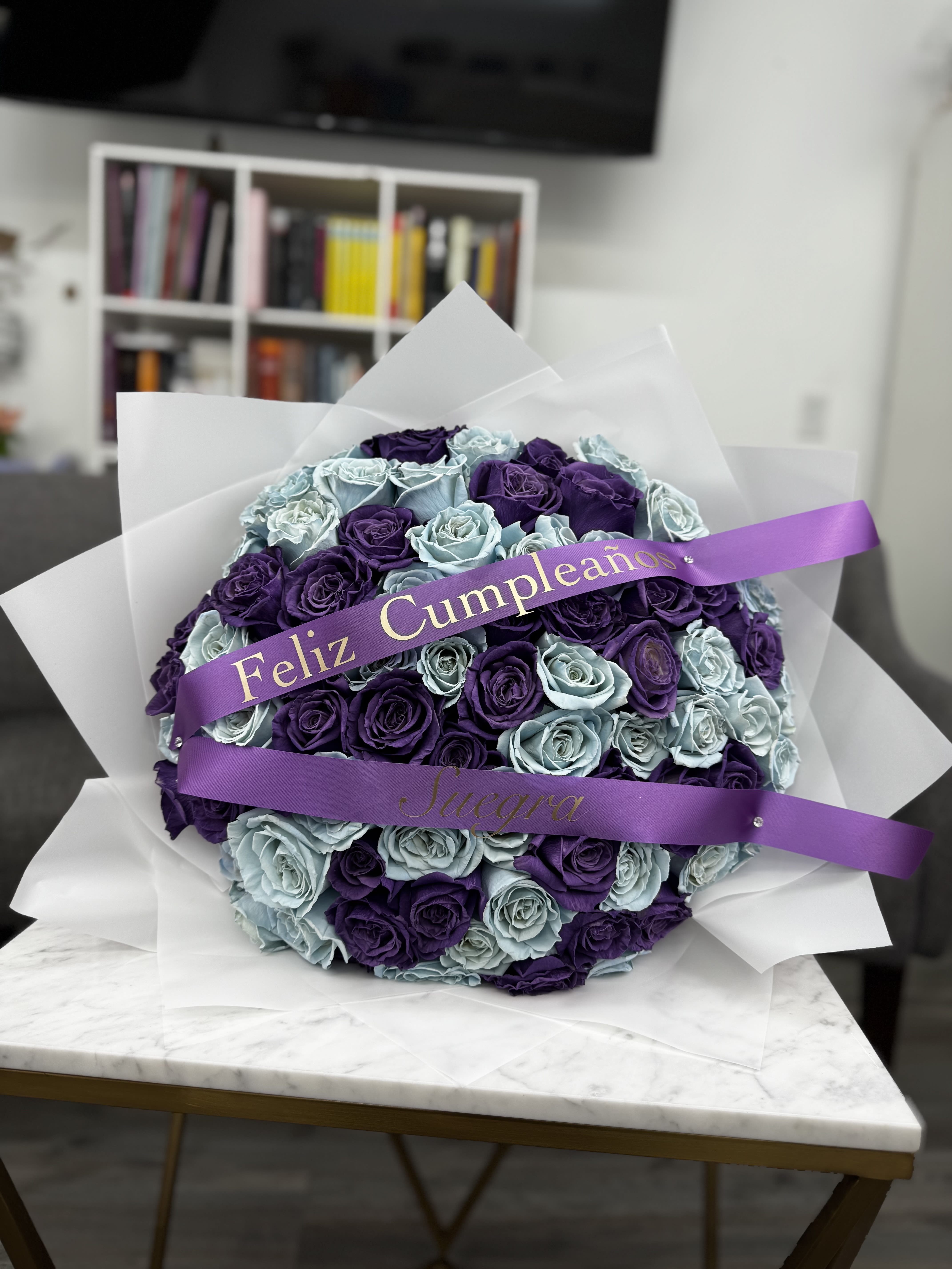 Round bouquet of purple and light blue roses with a birthday ribbon
