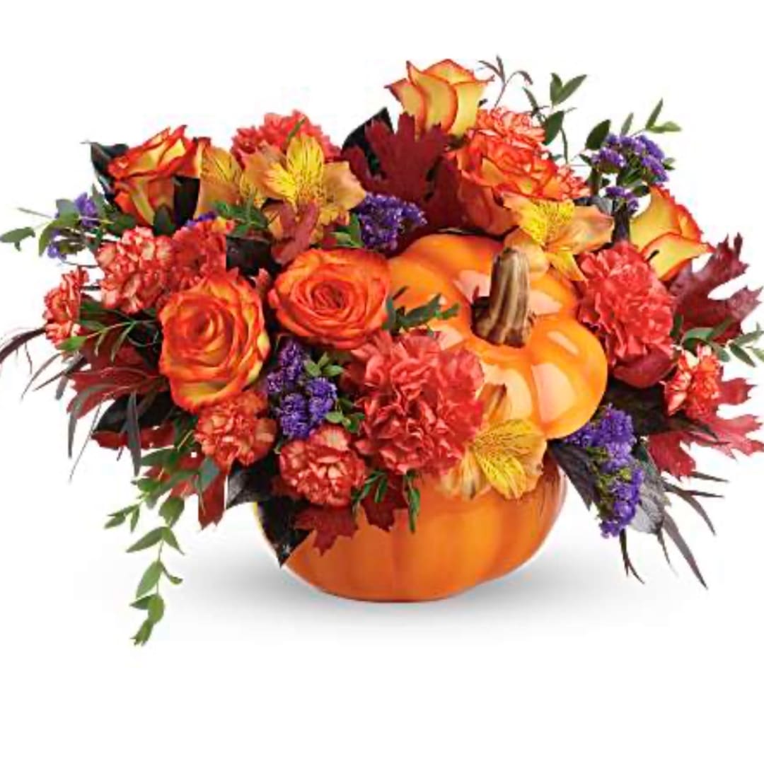Autumn floral arrangement in a pumpkin container with orange and purple flowers