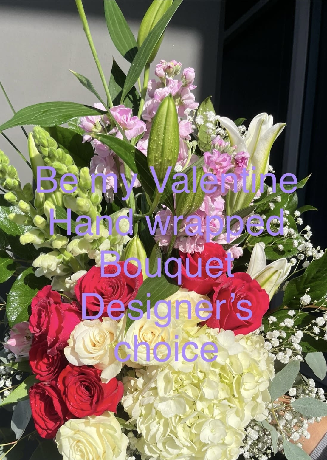 Hand-wrapped bouquet of red and cream roses with pink lilies