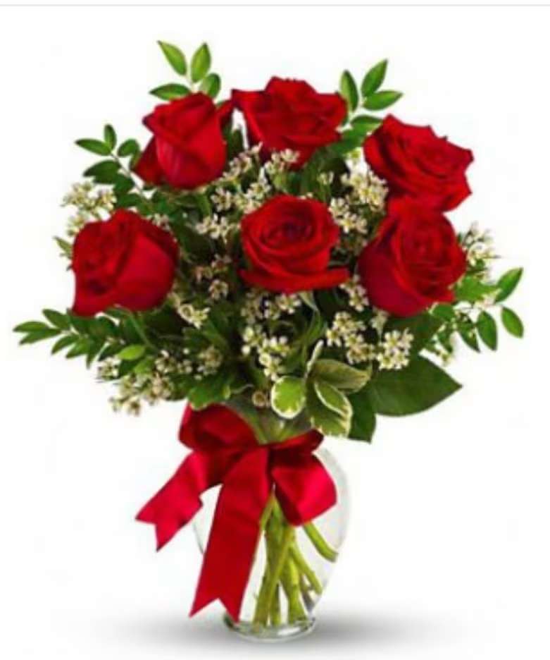 Bouquet of red roses with greenery in a clear glass vase