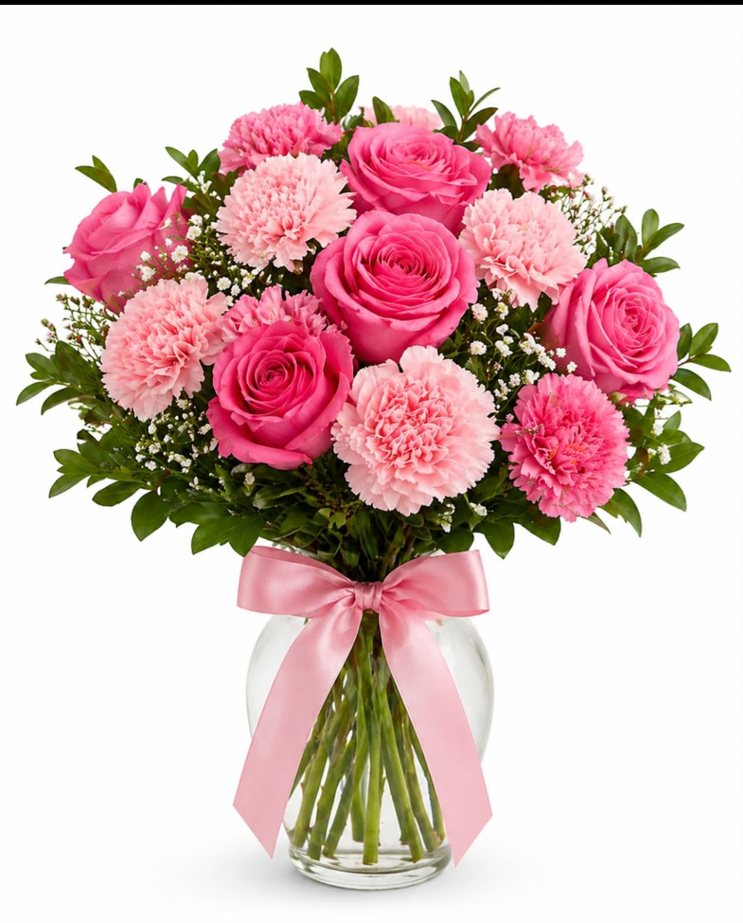 Blushing Rose Charm - A timeless everydy bouquet featuring radiant pink roses paired with soft pink carnations, delicate baby's breath and lush greenery. Designed in a clear glass vase and accented with a satin pink bow.