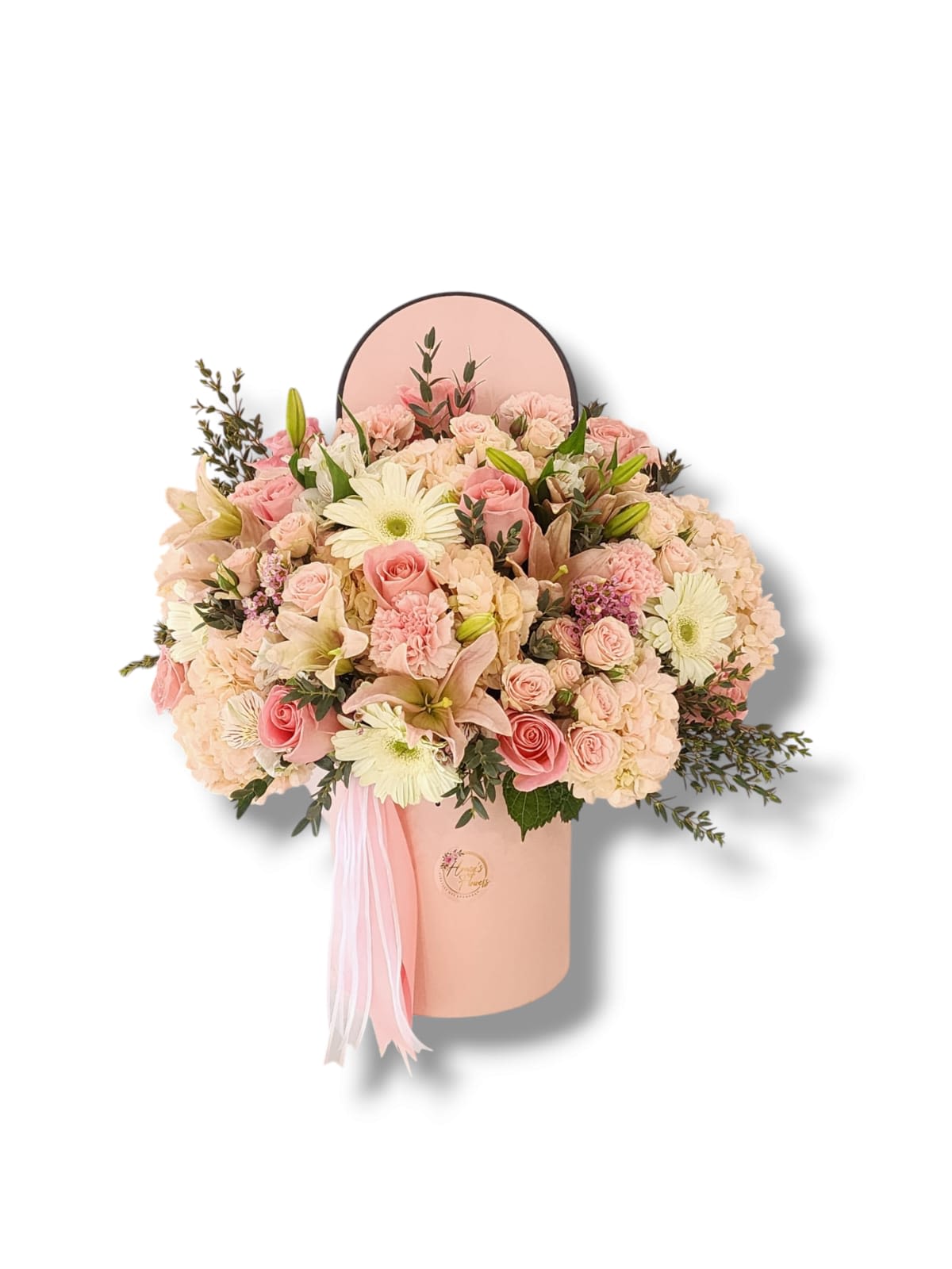 Pink and cream flower arrangement in a round hat box with ribbon