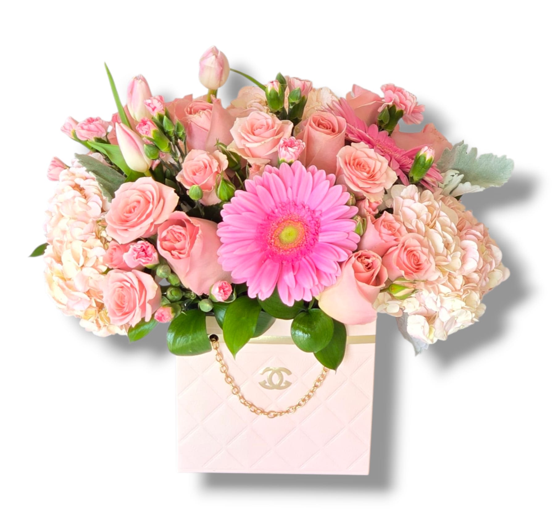 Pink roses and a gerbera daisy in a pale pink box bag