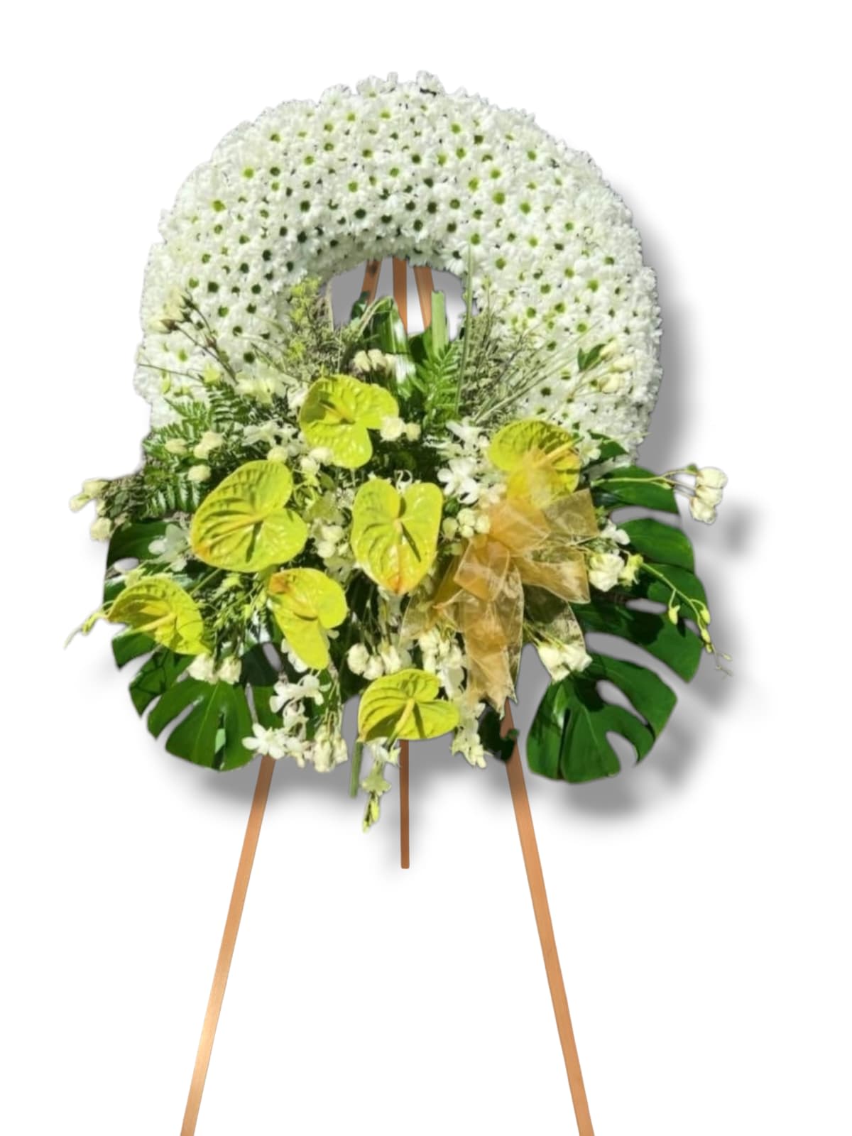 White floral standing wreath on an easel with green accents