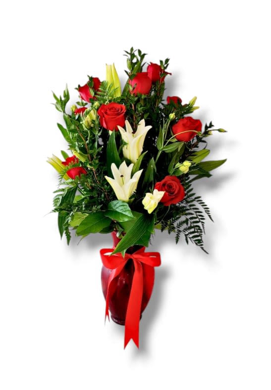 Red roses and white lilies in a red vase with a ribbon