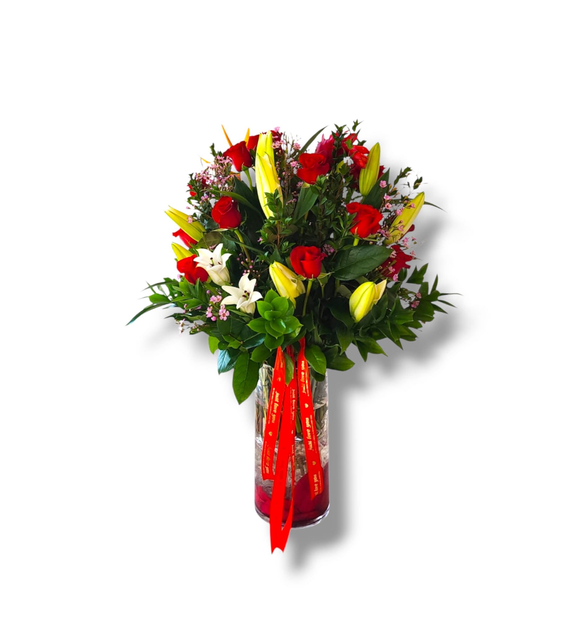 Bouquet of red roses and yellow lilies in a glass vase with a red ribbon