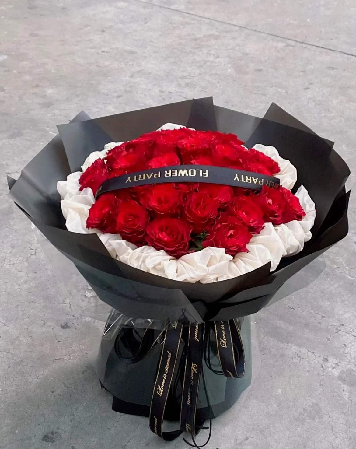 Bouquet of red and white roses wrapped in black paper