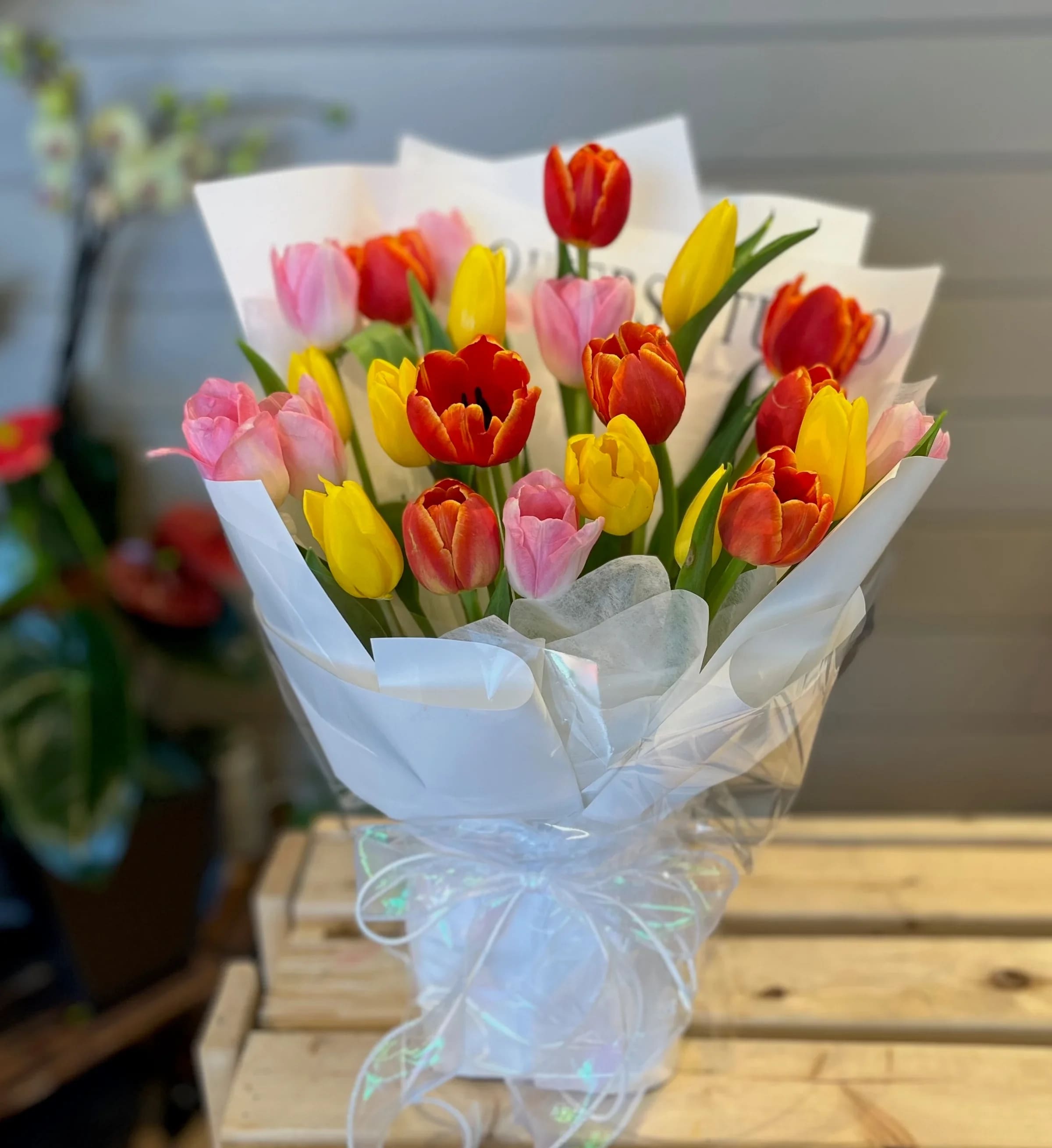 Bouquet of multicolored tulips wrapped in white paper