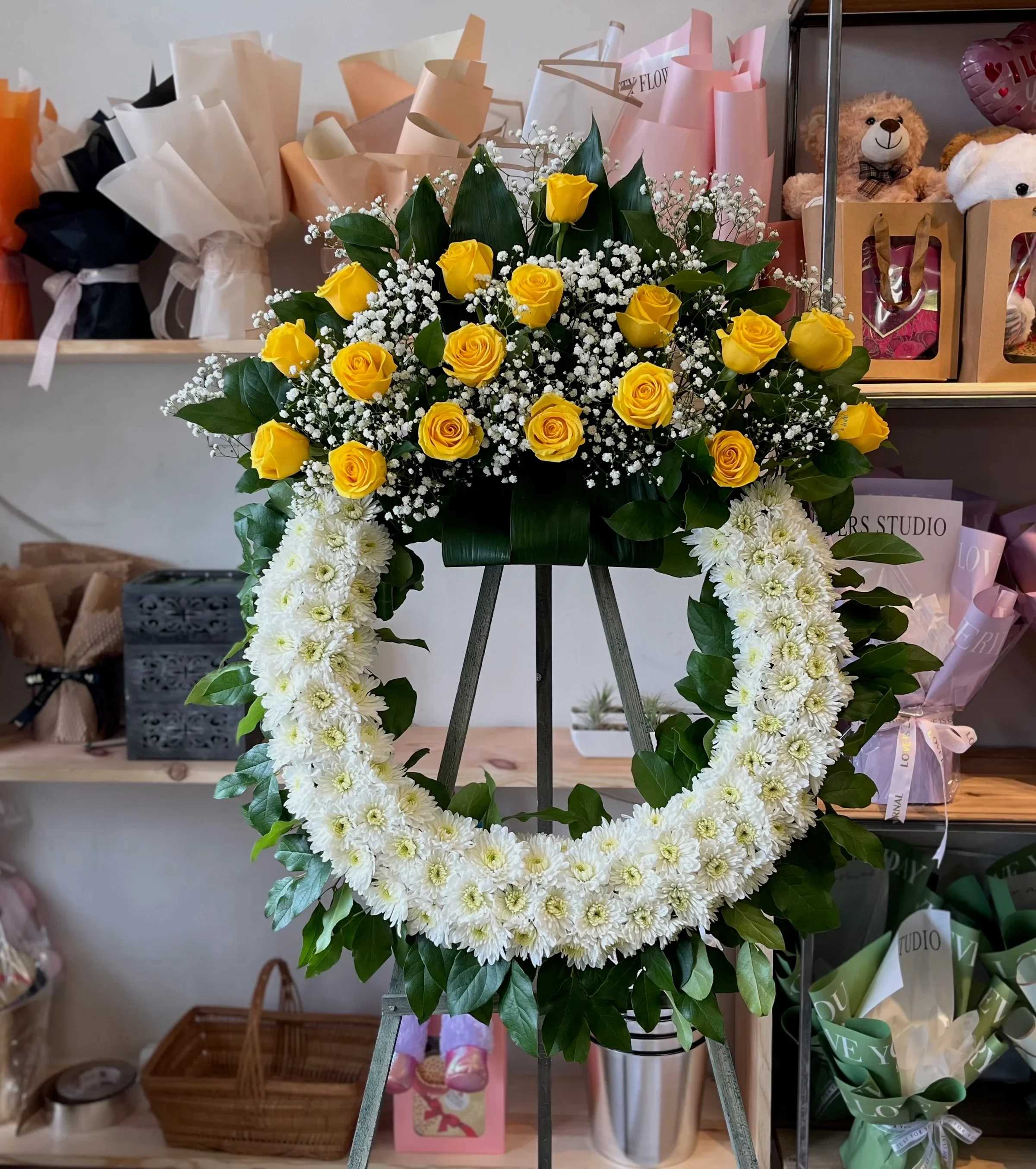 Yellow roses and white chrysanthemum wreath on an easel