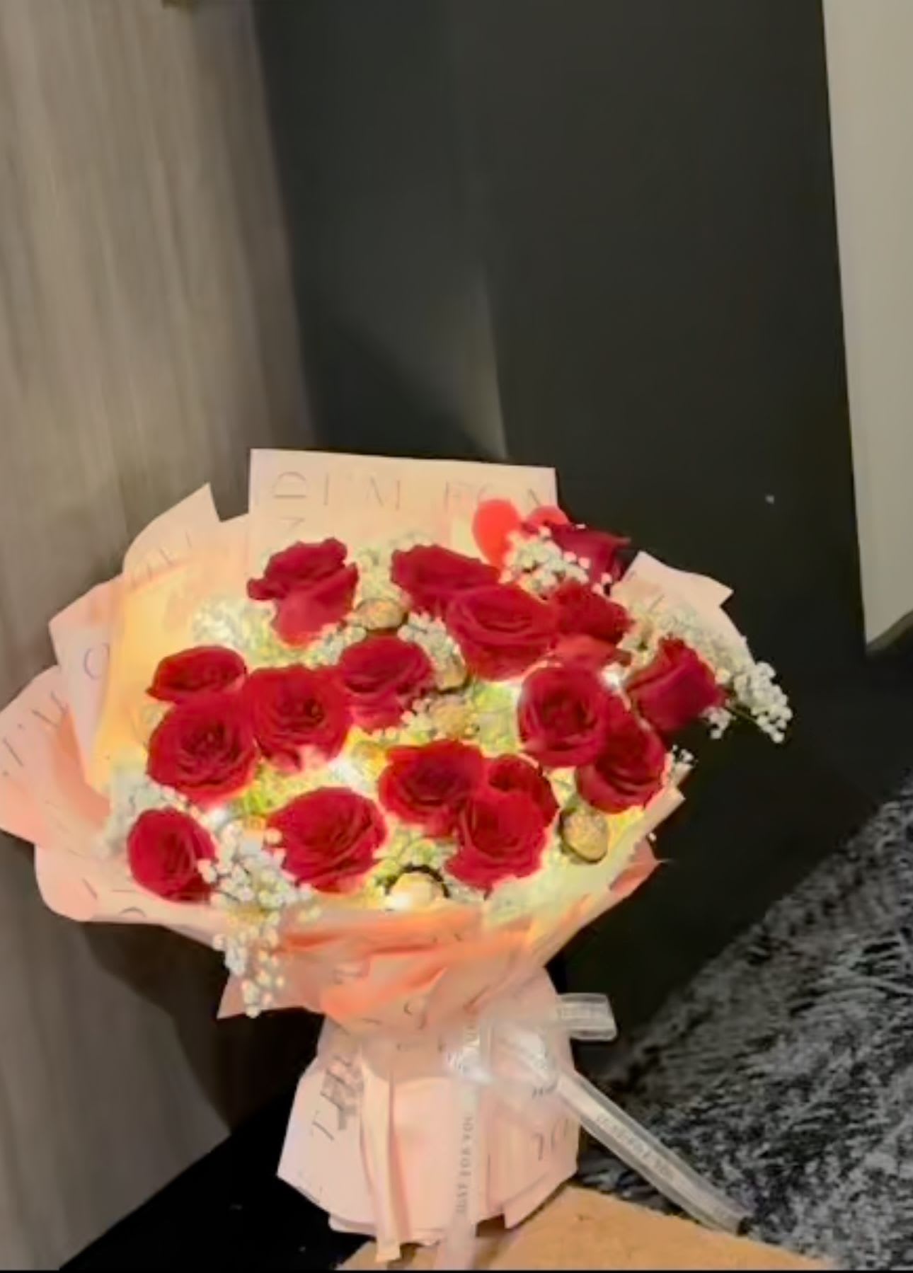 Bouquet of red roses wrapped in pale pink paper