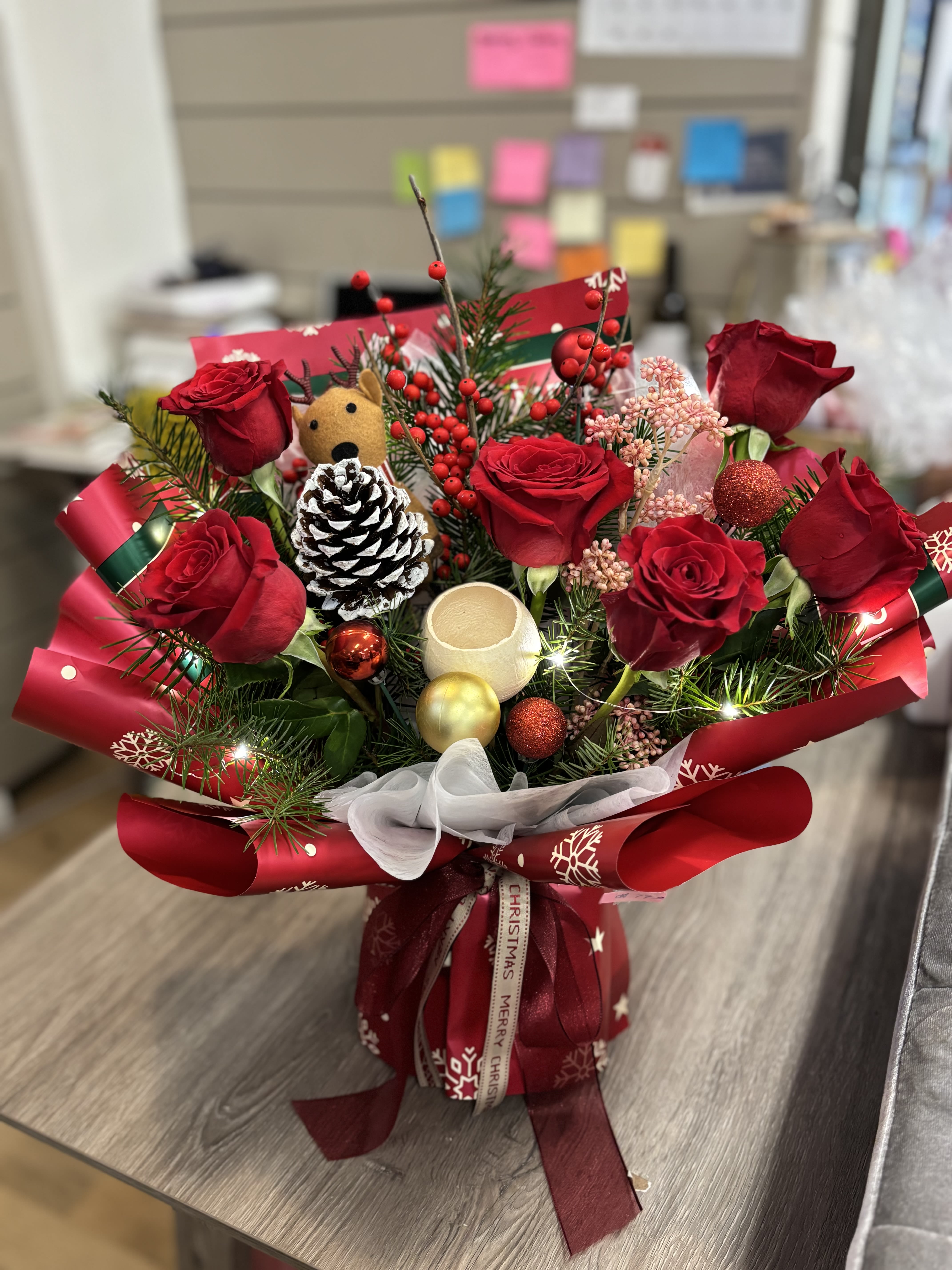 Red rose bouquet with Christmas ornaments and ribbon wrap