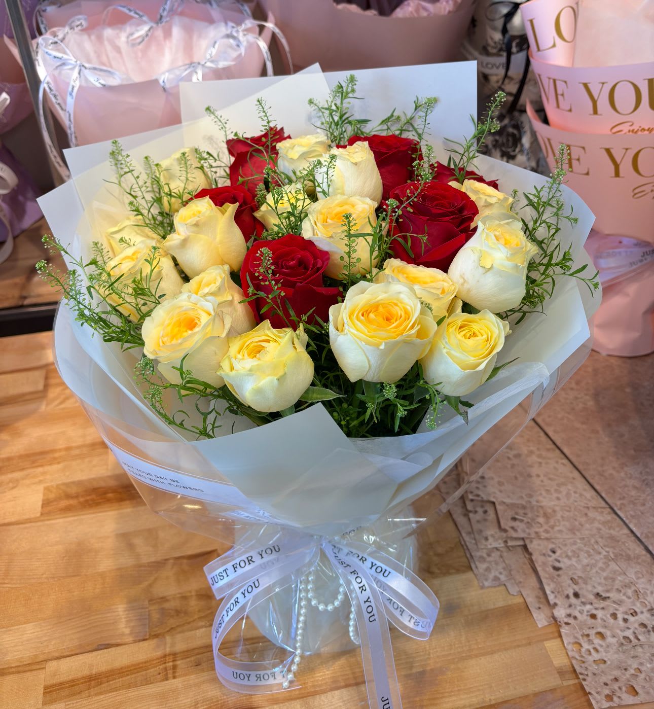 Bouquet of red and cream roses wrapped in white paper