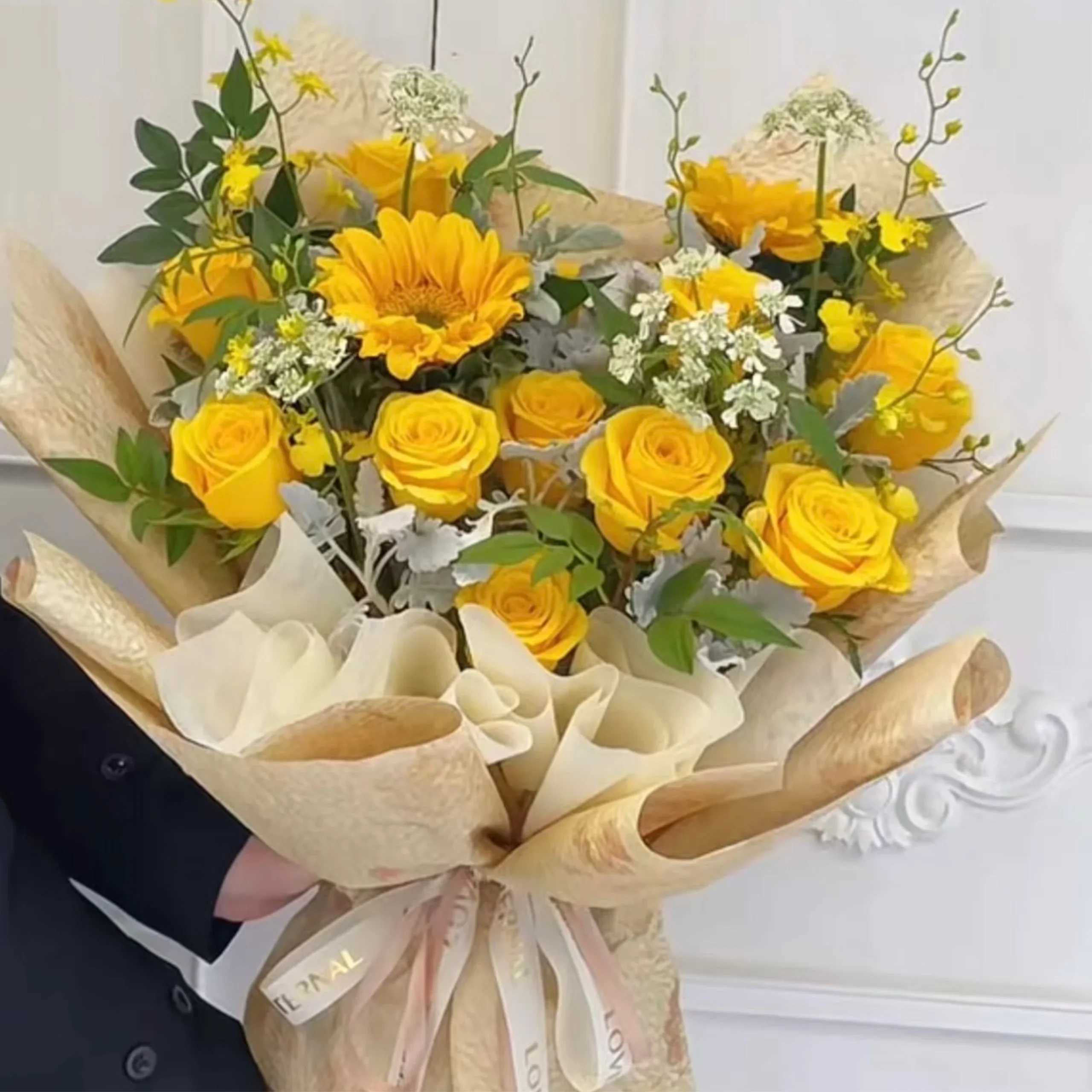 Bouquet of yellow roses and a sunflower wrapped in beige paper
