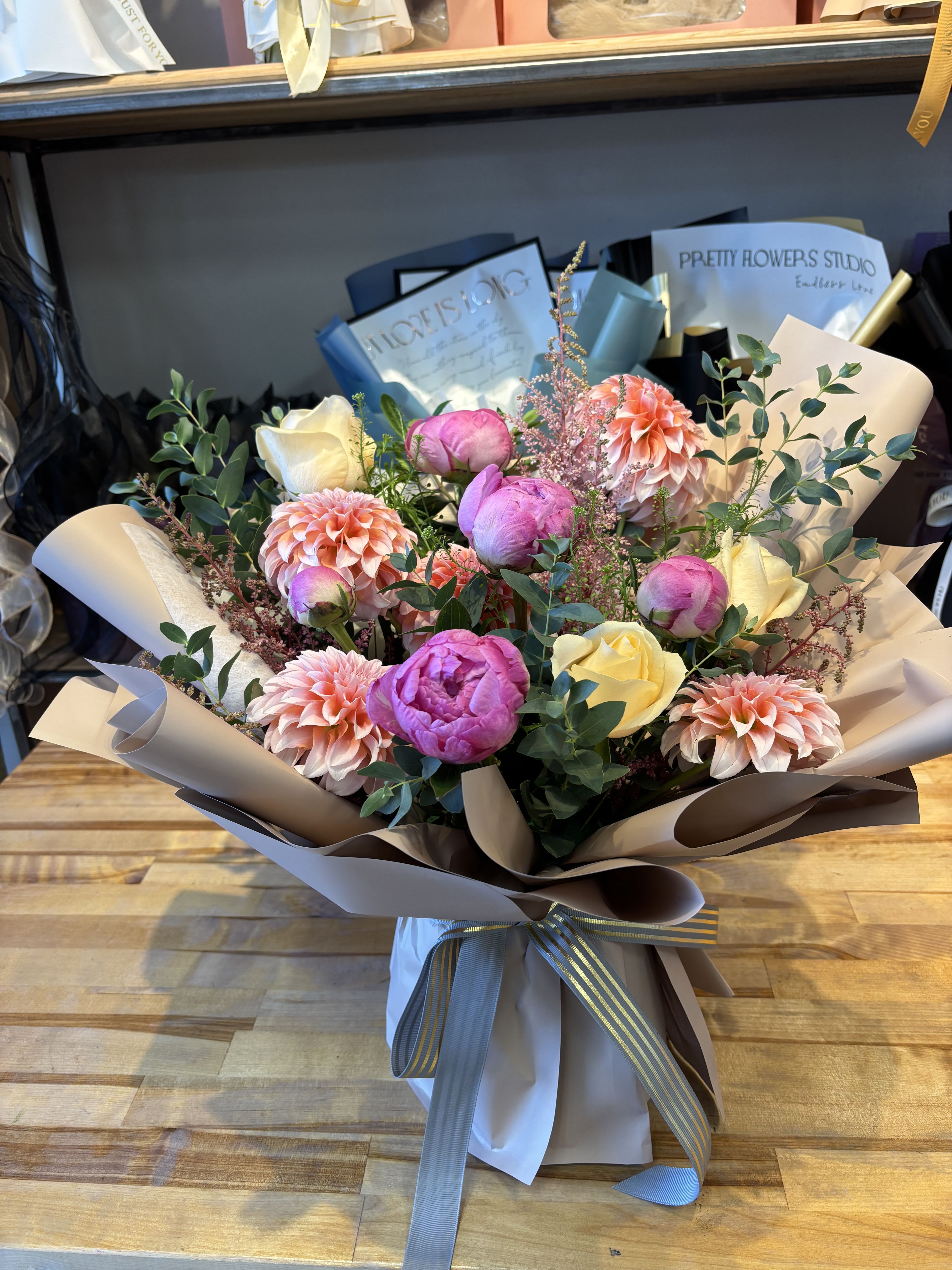 Bouquet of pink and cream flowers wrapped in paper