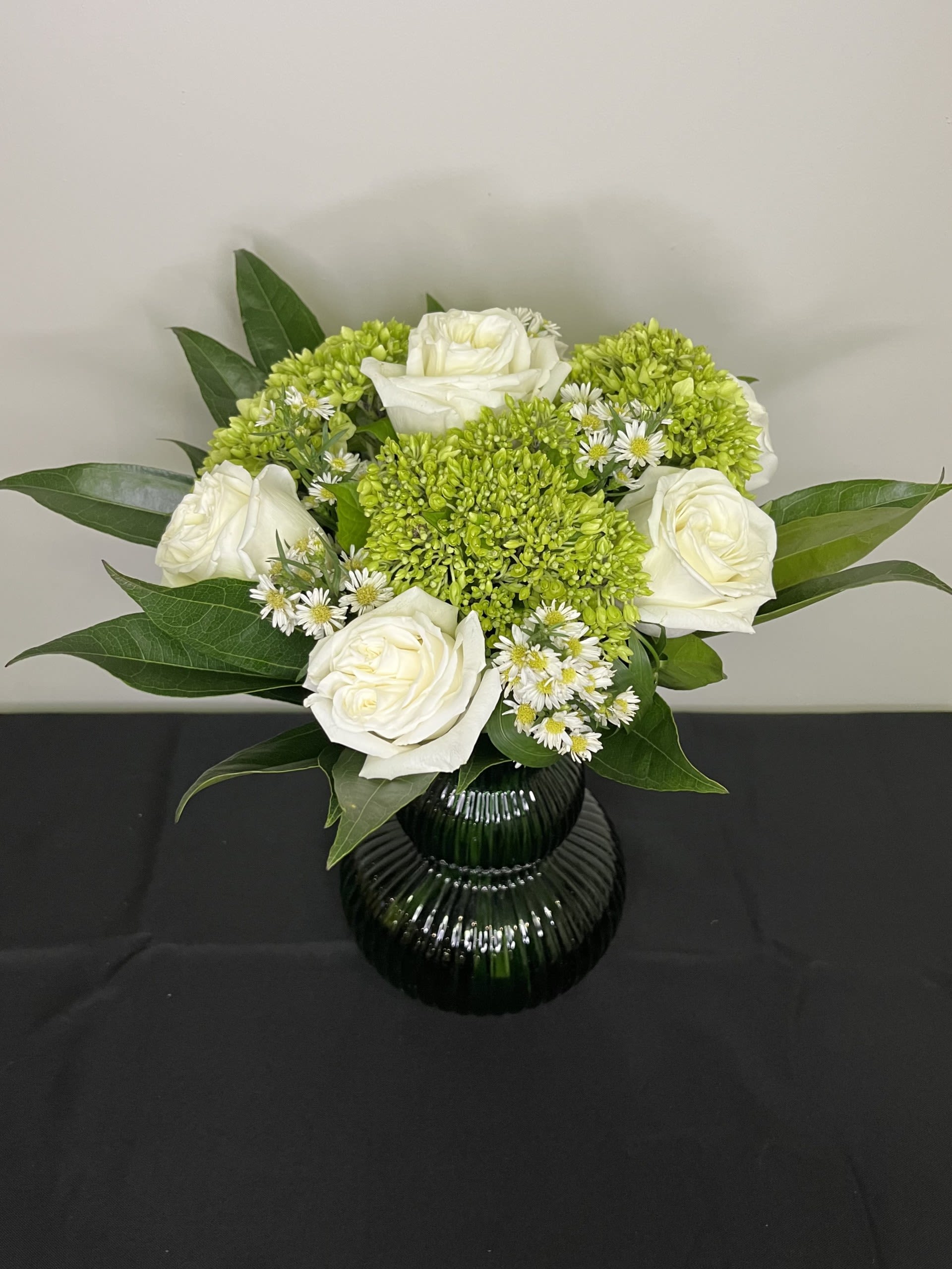 Winter Daydream by Chasing Petals - Clean and fresh, this bouquet will bring a breath of fresh air into any room.  Beautiful white roses arranged with green hydrangeas and greenery in a gorgeous green vase, you can't go wrong.