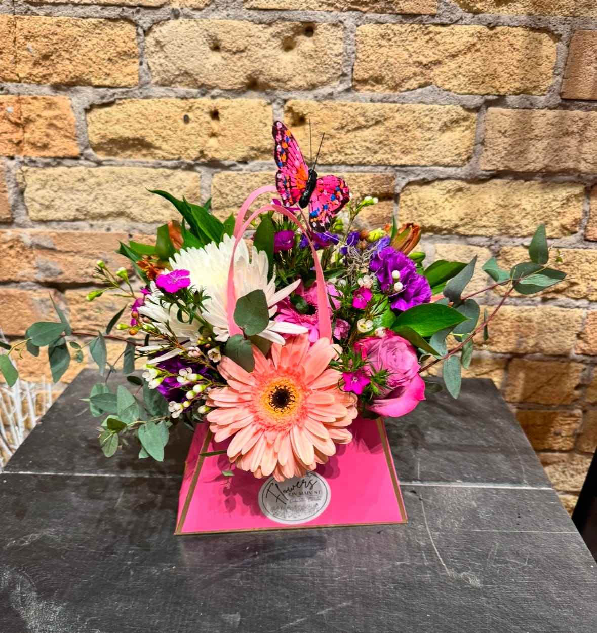 Pink and white mixed bouquet in a bright pink gift box with a butterfly topper