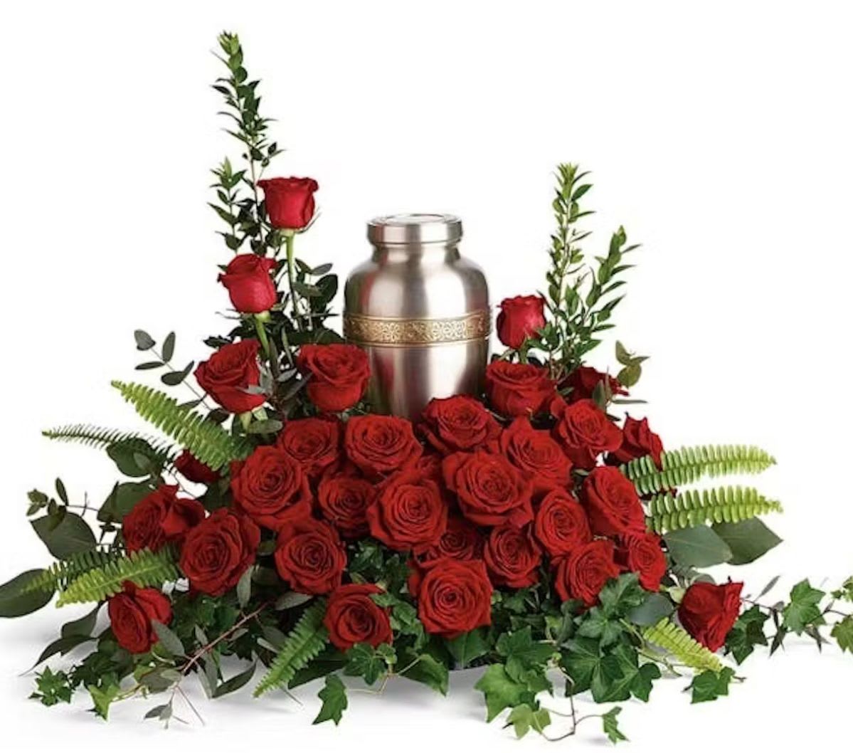 Red roses arranged around a silver urn with greenery