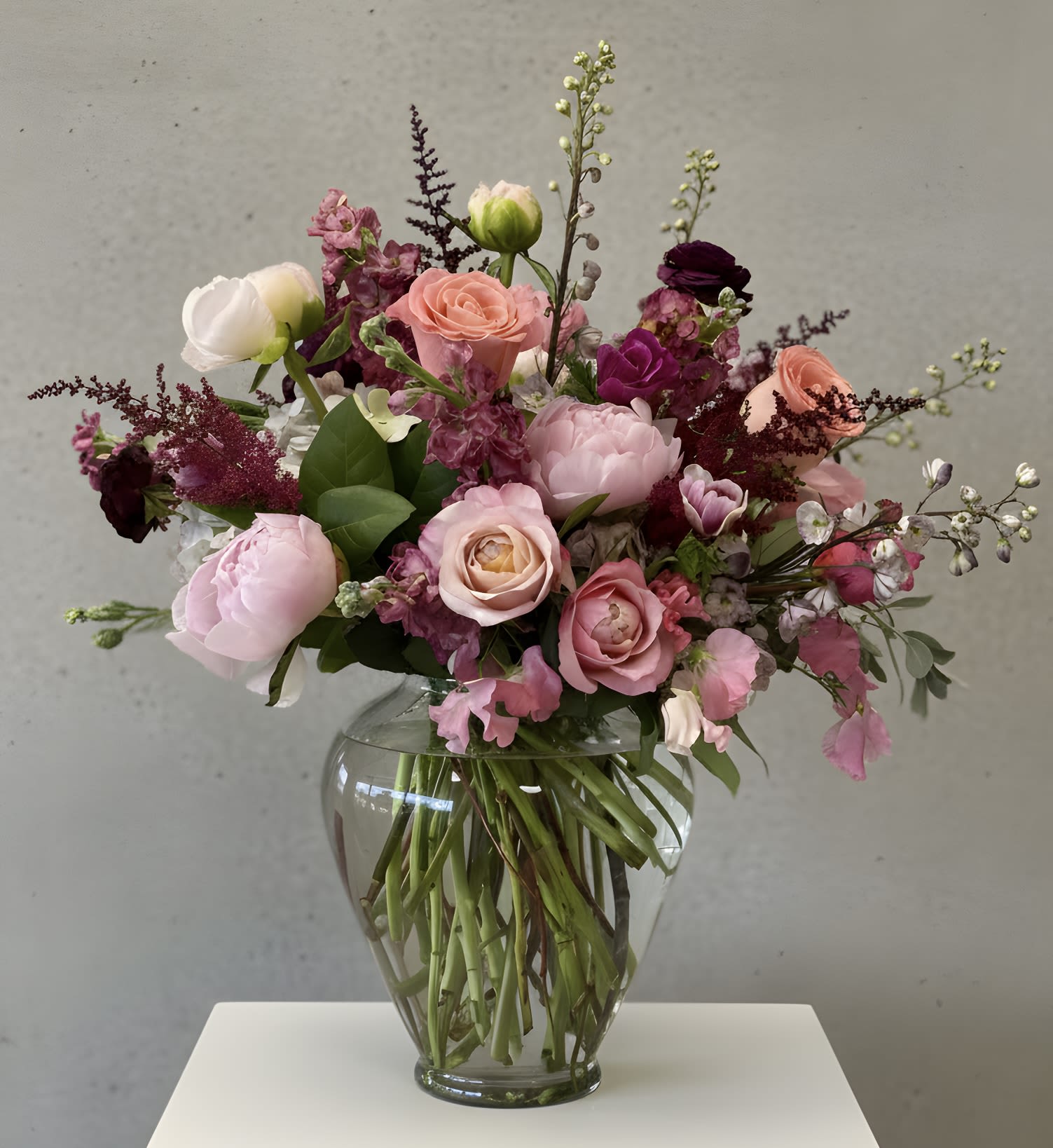 Twilight in Bloom - A romantic garden inspired arrangement featuring layers of blush pink, mauve, maroon and soft ivory blooms artfully gathered.