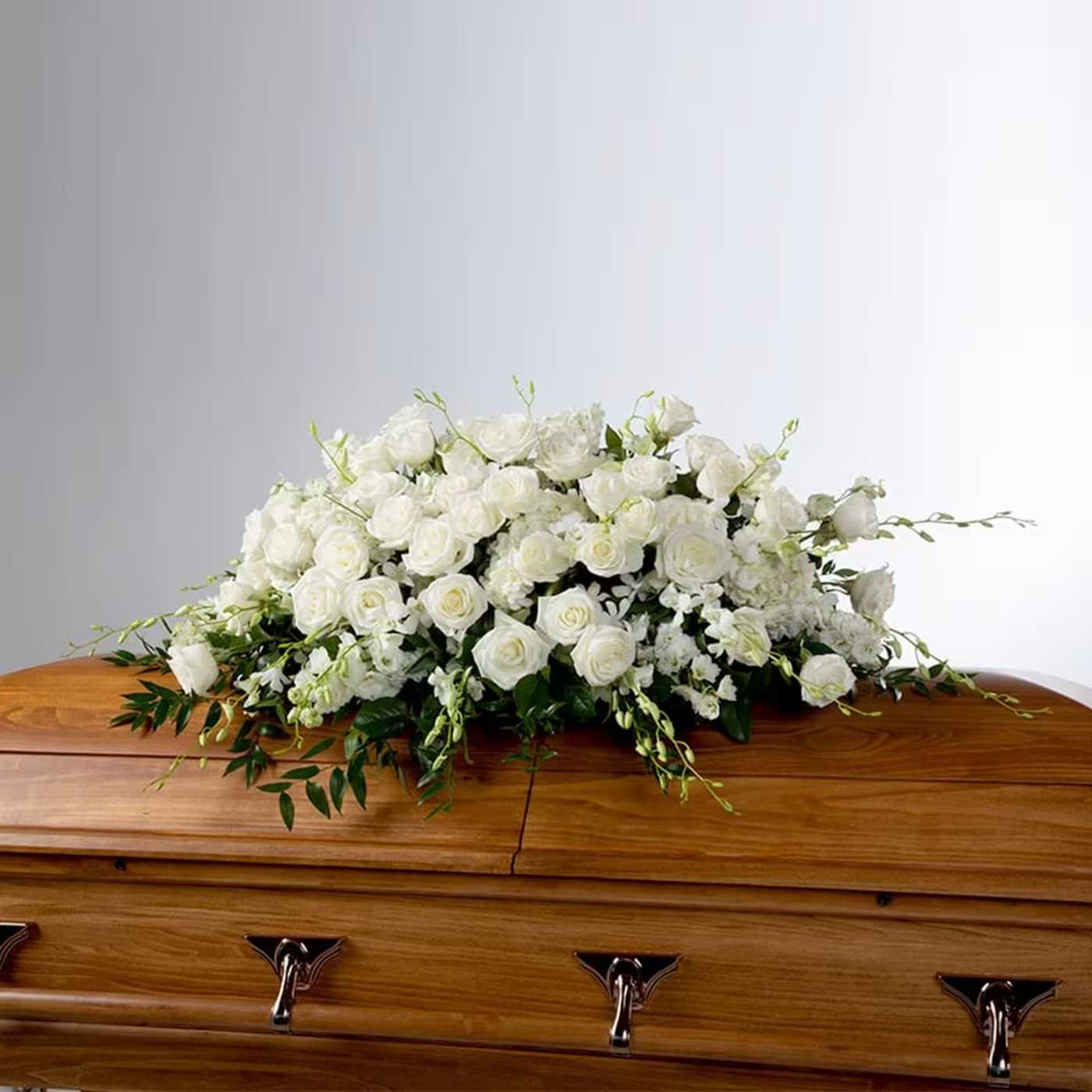 Tranquility by BloomNation - An all white tribute, this full casket spray is pure and tranquil. Featuring a variety of white flowers and greenery, this elegant spray evokes a feeling of peace.