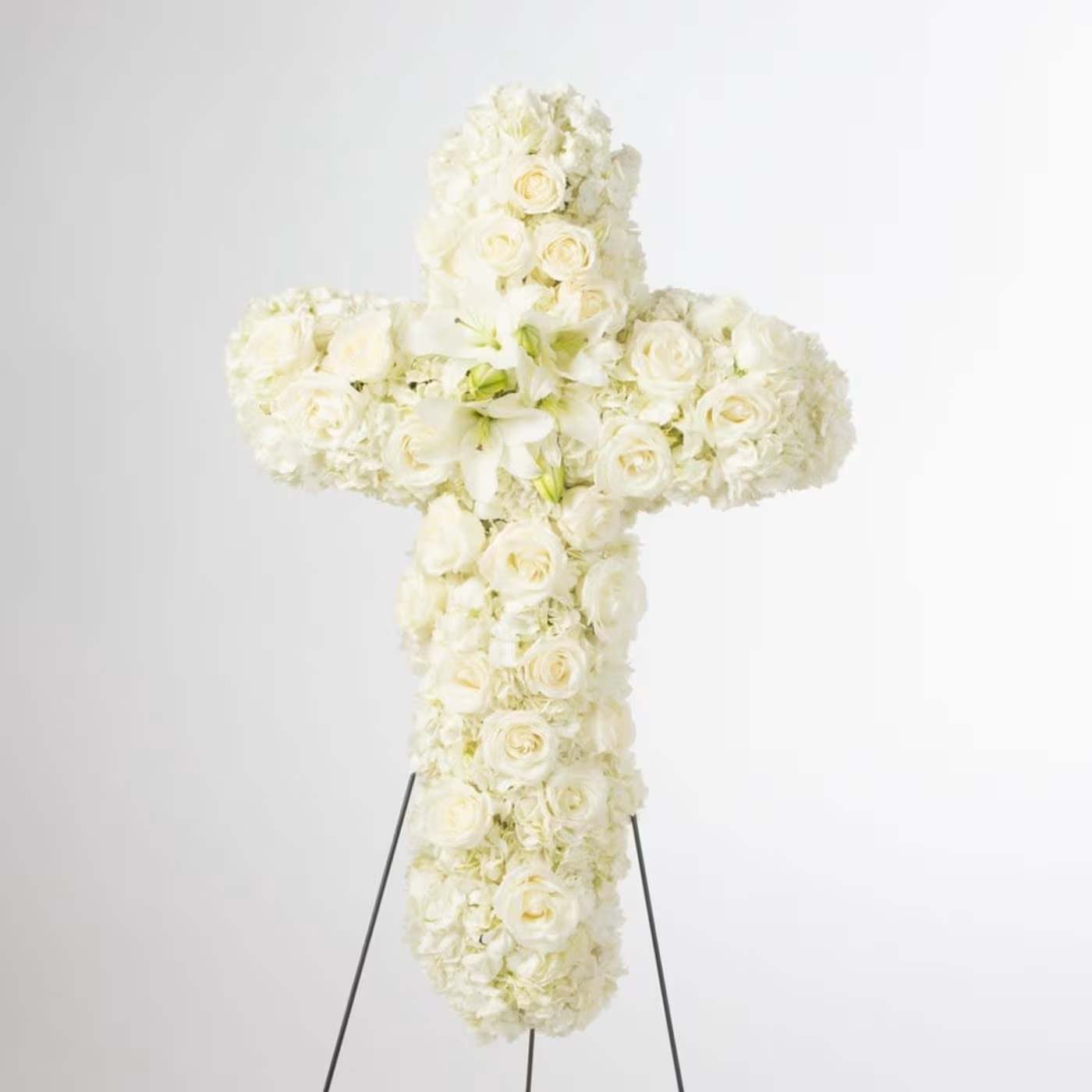 Faith - An all white tribute, this white cross funeral spray is pure and tranquil. Featuring a variety of white flowers, this elegant easel compliments the beauty of life.