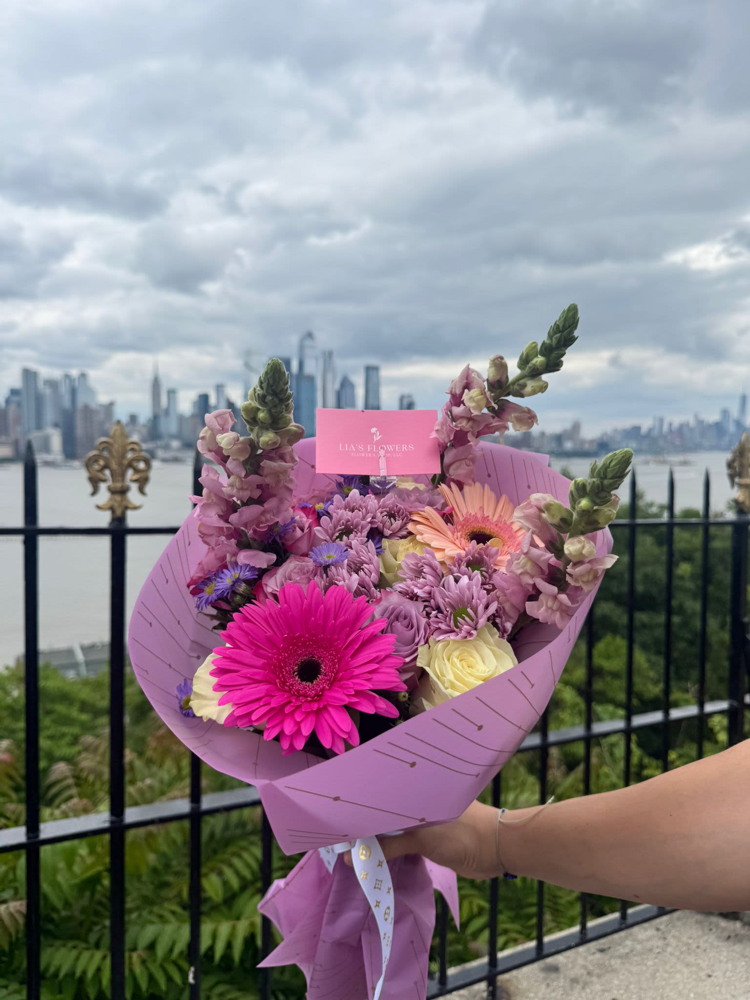Metropolitan Romance - Una fusión perfecta entre elegancia urbana y dulzura floral. Este bouquet destaca por su envoltura lavanda lavanda y una cuidada selección de flores frescas en tonos rosa, lila y crema, que evocan romanticismo y modernidad.