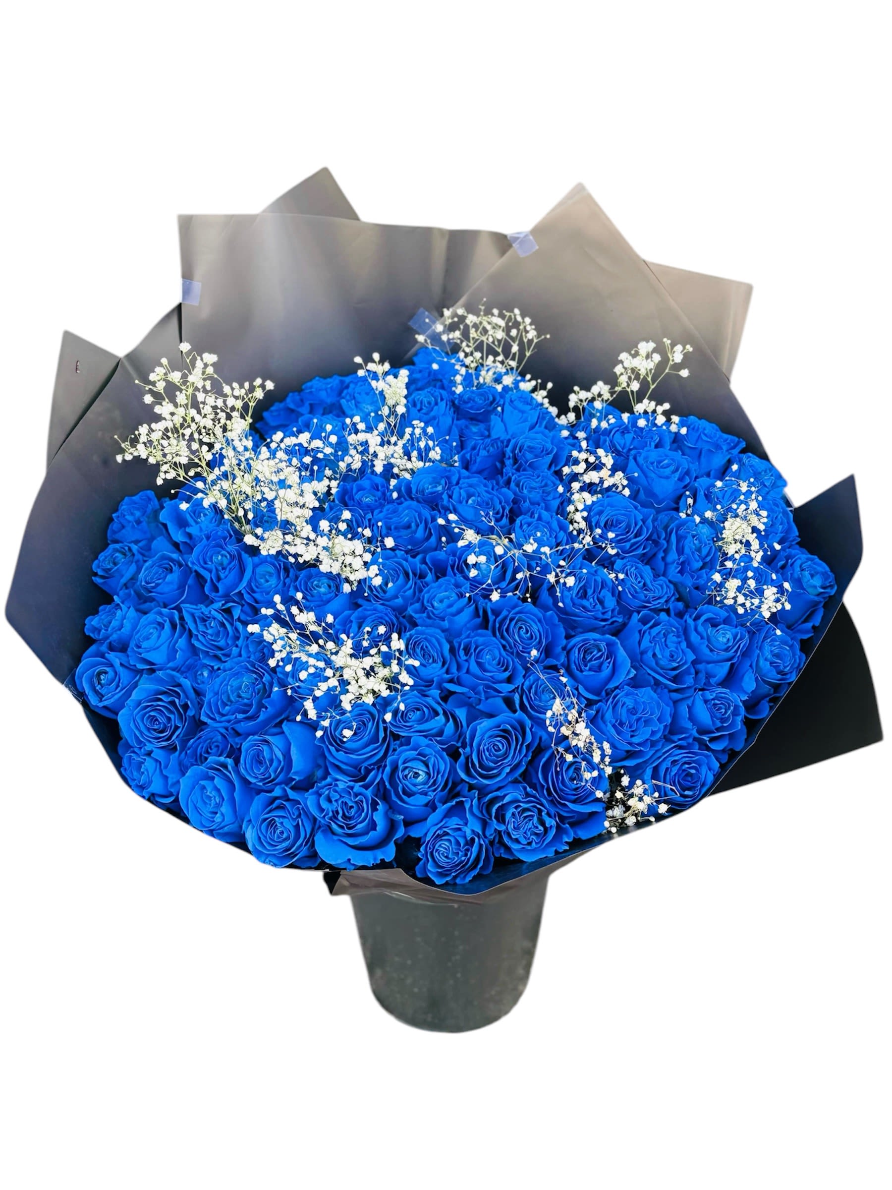 Large bouquet of vivid blue roses with small white filler flowers wrapped in black paper