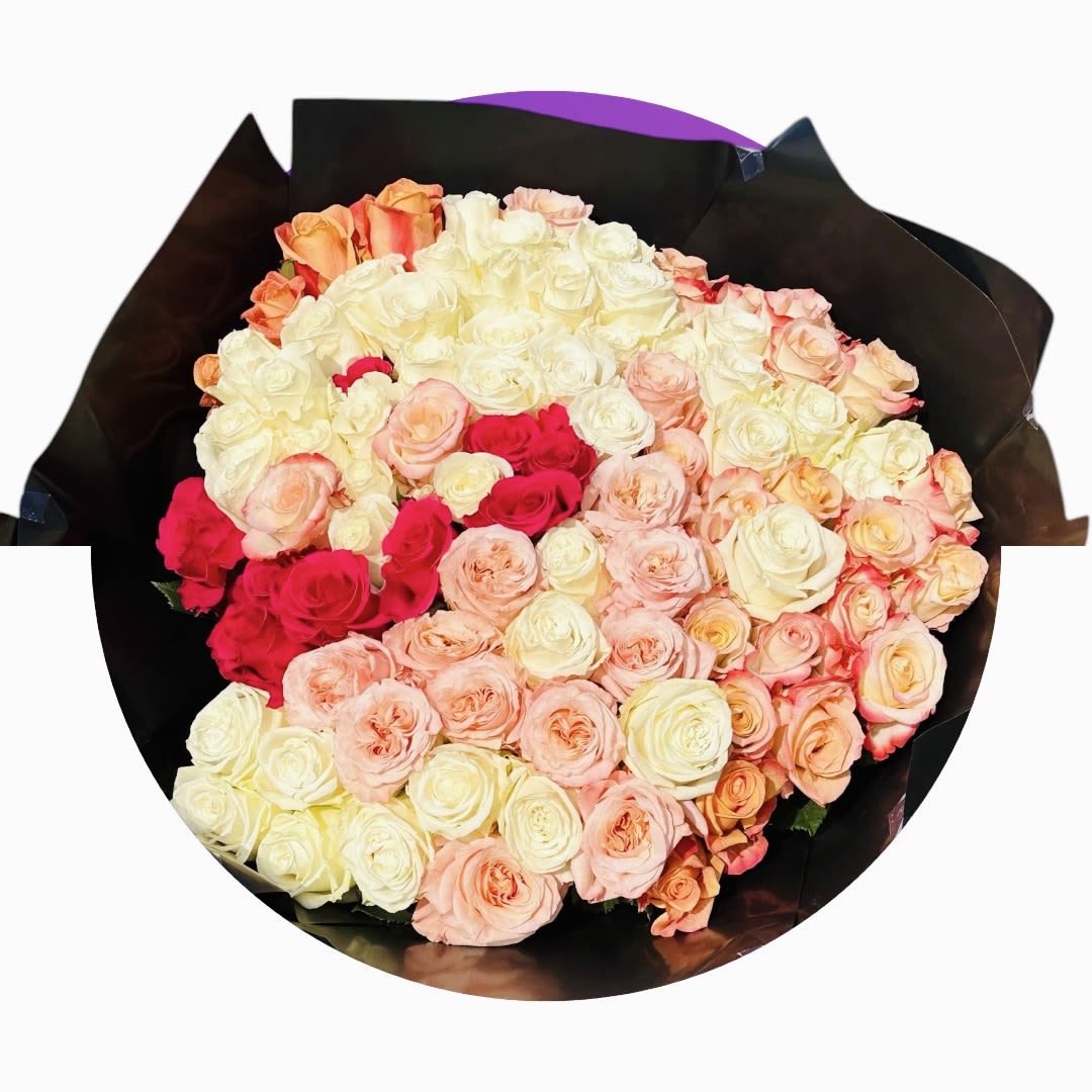 Large bouquet of cream, blush, and hot pink roses wrapped in black paper