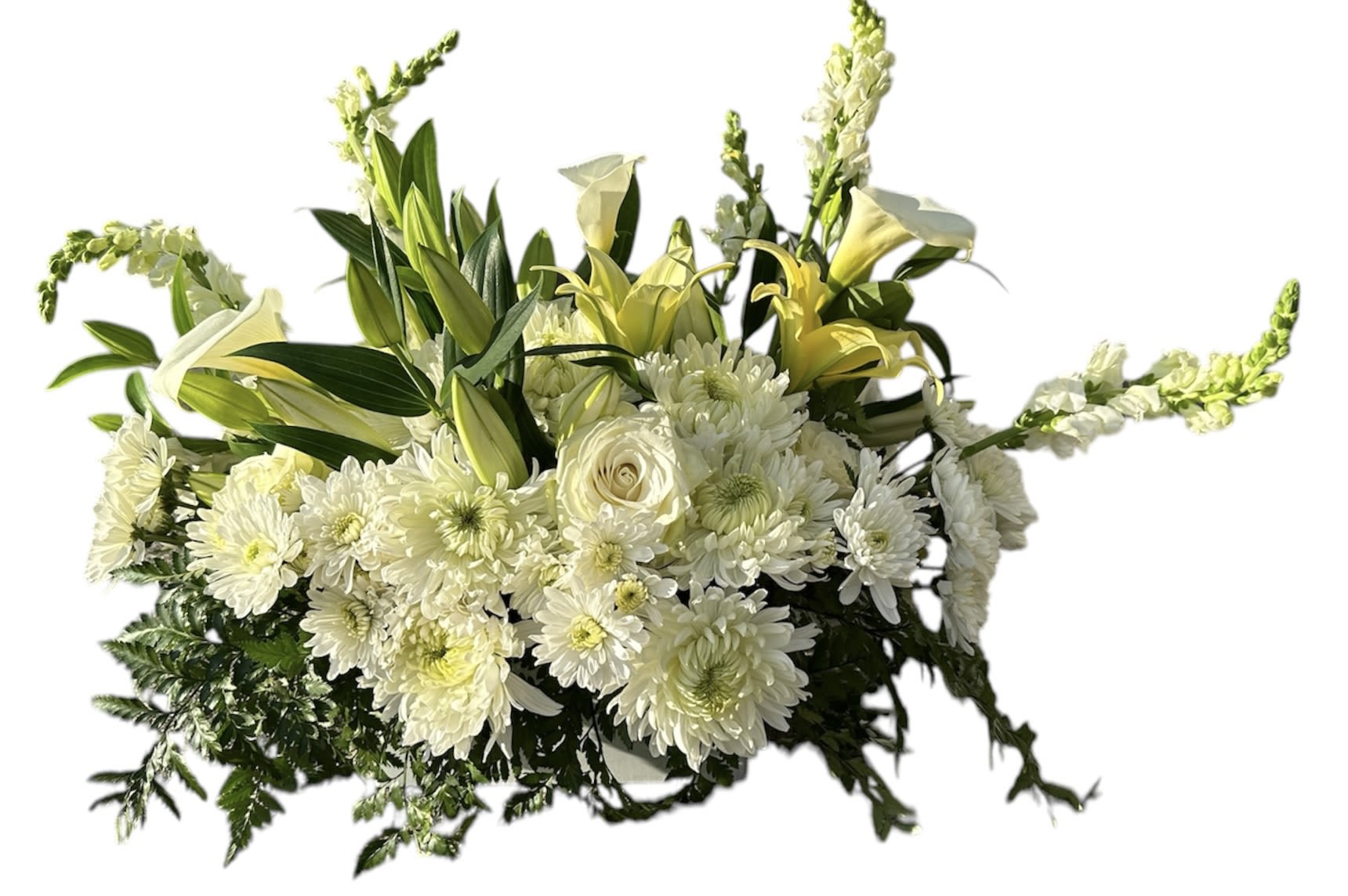 Low white and soft yellow floral arrangement with lilies, roses, chrysanthemums, and snapdragons