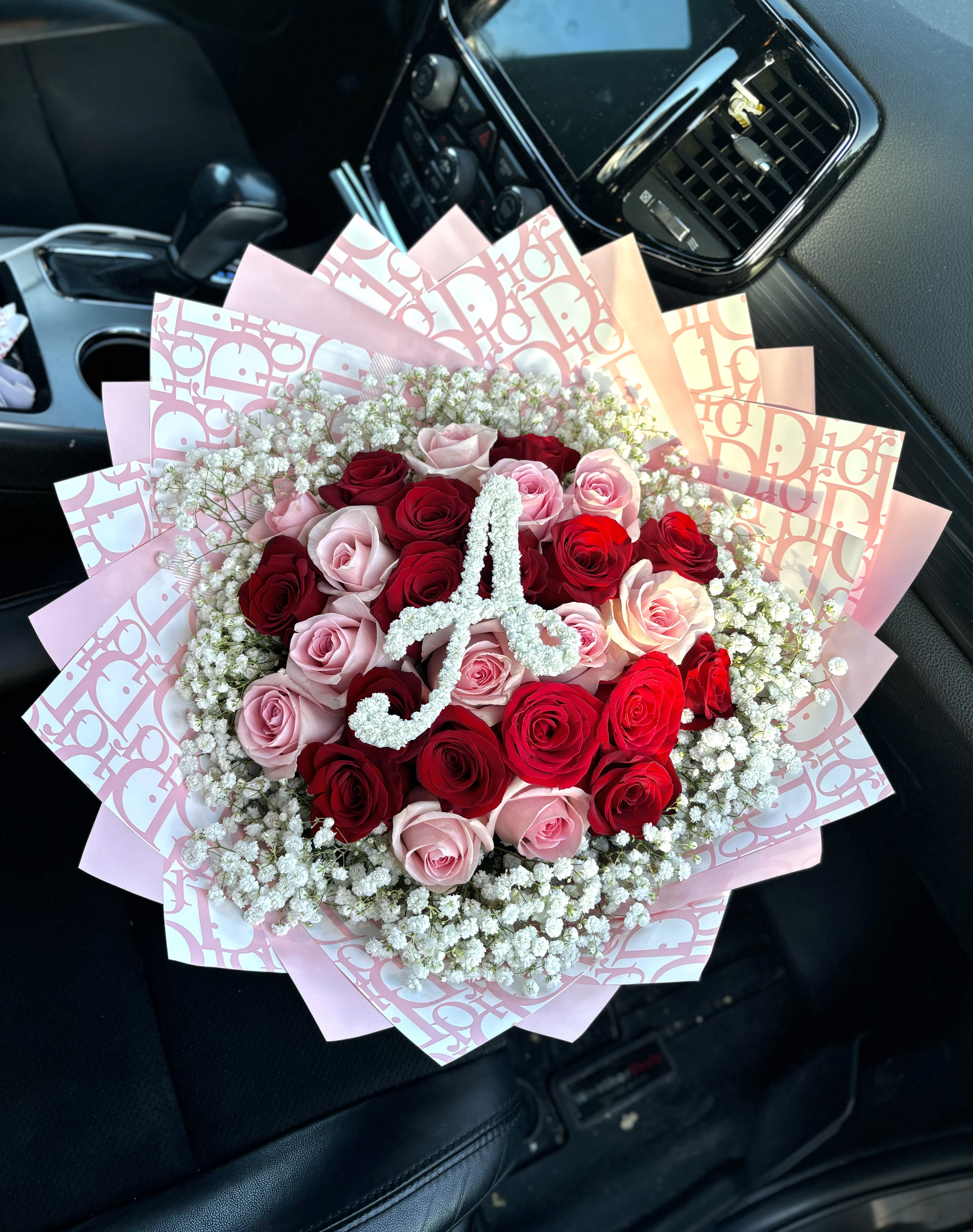 Bouquet of red and pink roses with baby's breath in pink wrapping
