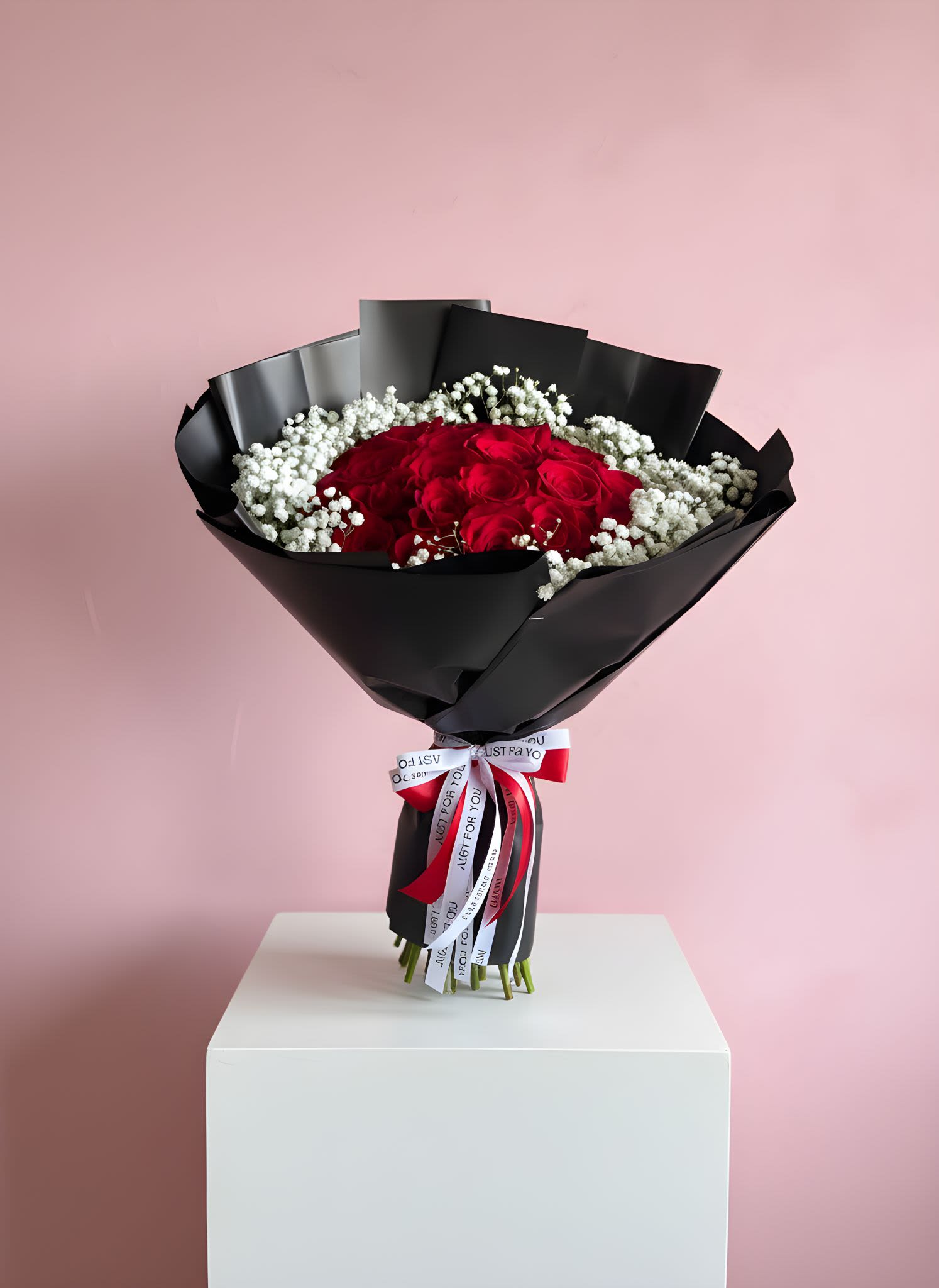 Bouquet of red roses with white baby's breath in black wrap
