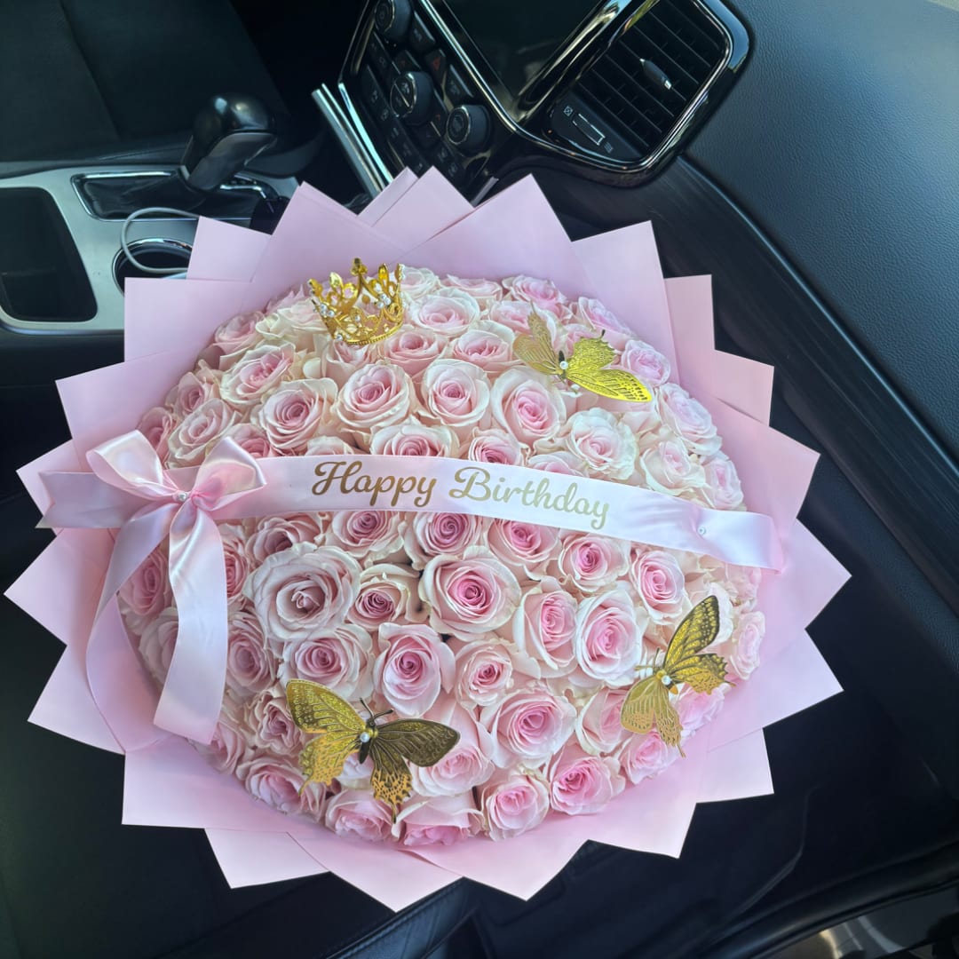 Pink rose bouquet with a birthday ribbon and gold butterfly decorations