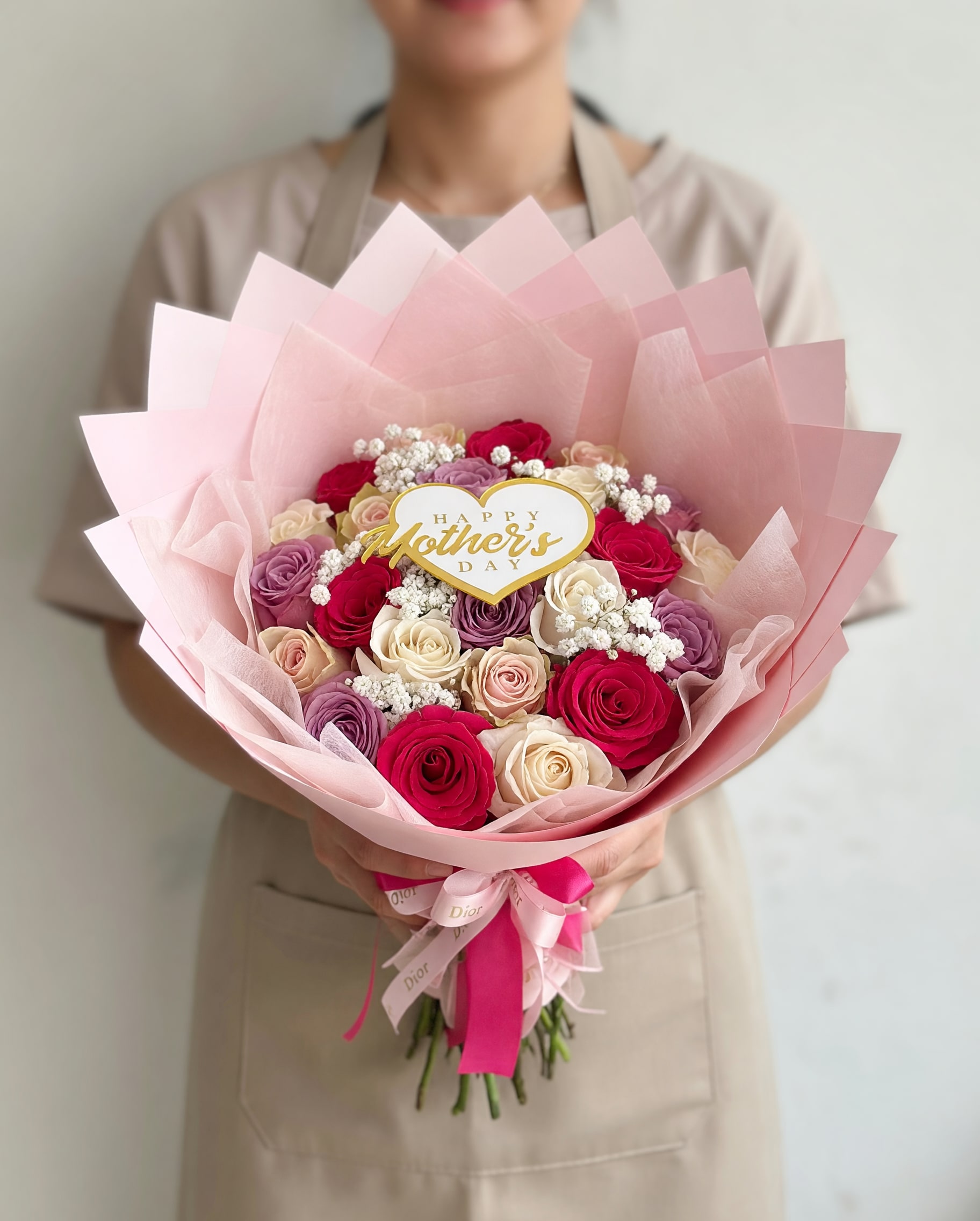 25 Multicolor Mom Bouquet - Make her feel truly special with our Blush Garden 50 Rose Bouquet, a luxurious arrangement designed to impress. This stunning bouquet features 50 fresh roses in a delicate blend of soft pink, ivory, and lavender tones, creating a romantic and elegant color palette perfect for Mother’s Day.  Handcrafted in a full, round style and wrapped in premium white and blush paper with a satin ribbon, this bouquet is both timeless and eye-catching. Whether you’re celebrating Mom, a loved one, or a meaningful moment, this design speaks with beauty, softness, and love.  Includes 25-50 roses. Rose tones may vary slightly based on availability. Fresh flowers.