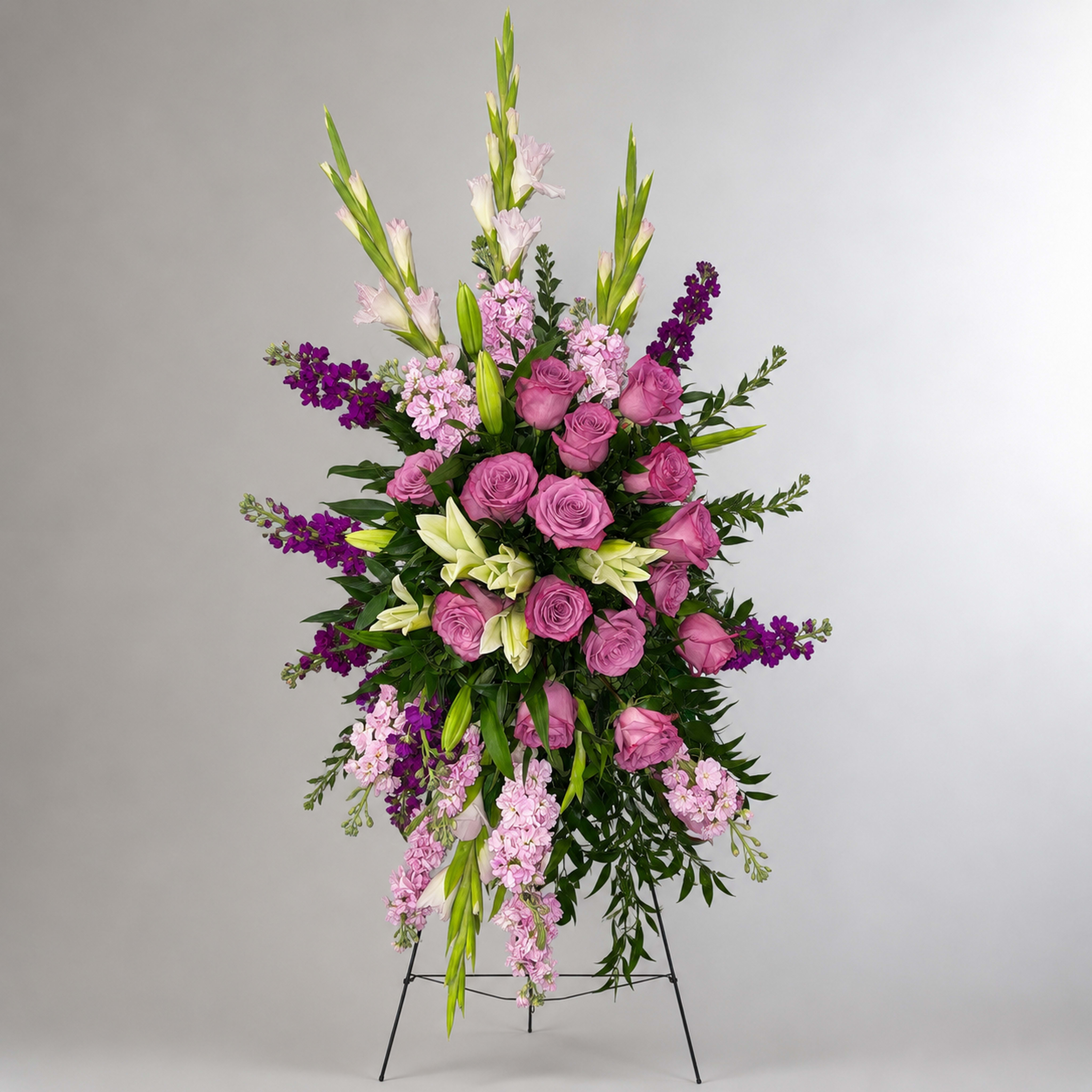 Tall standing floral spray with pink roses, lilies, and purple accents
