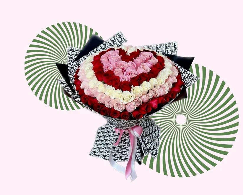 Heart-shaped bouquet of red, pink, and white roses with patterned wrapping