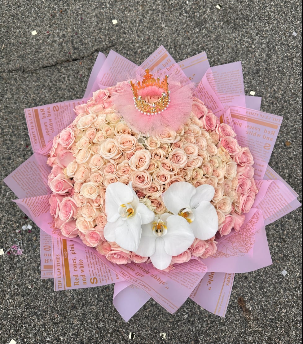 Pink rose bouquet with white orchids and a small crown topper