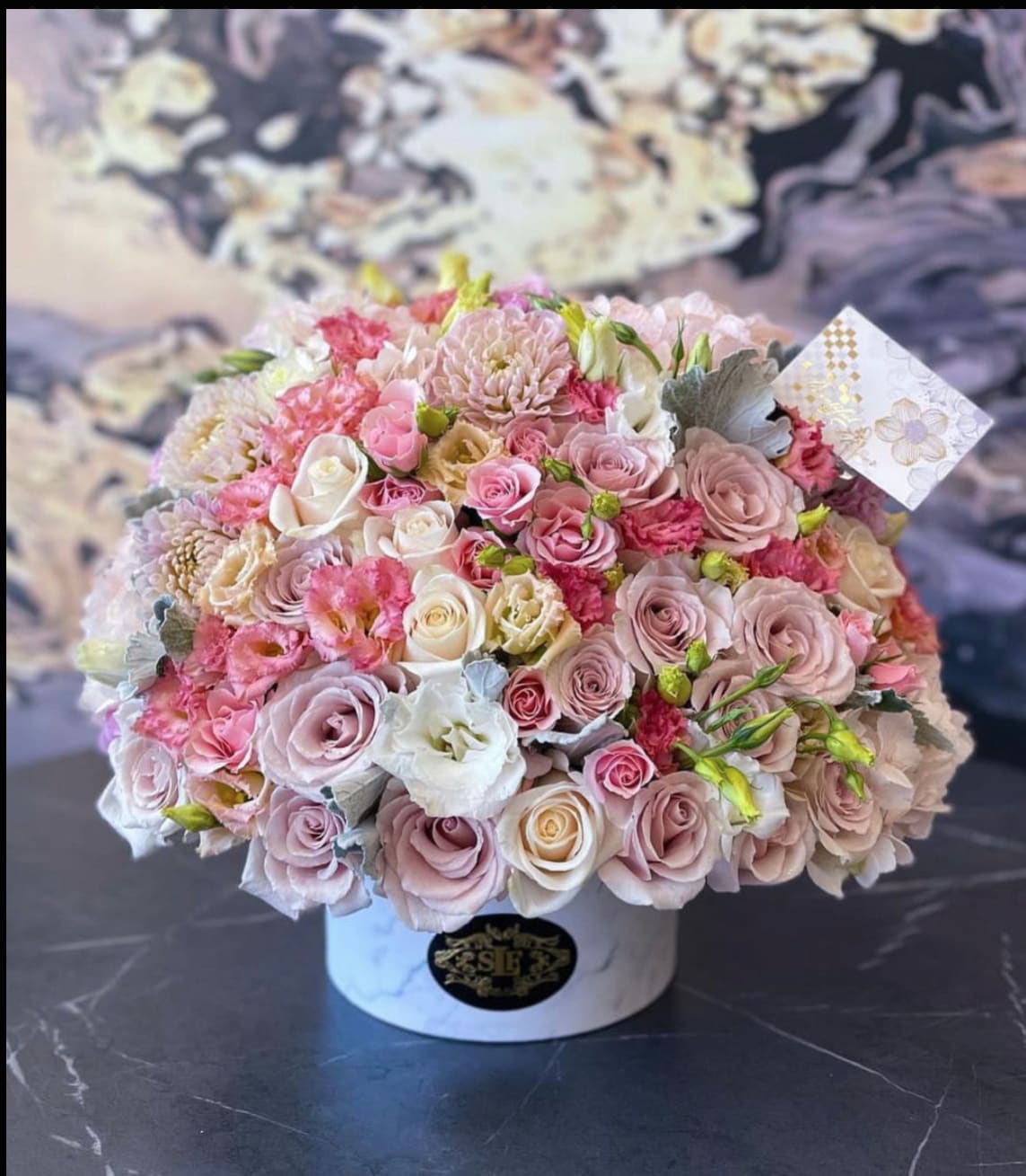 Round bouquet of pink and white roses in a white hat box