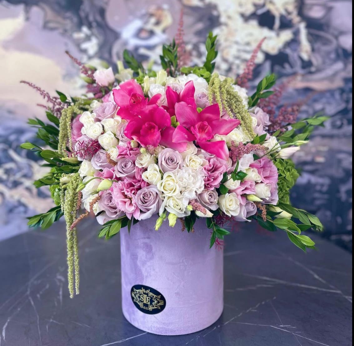 Pink and white floral arrangement in a lavender hat box