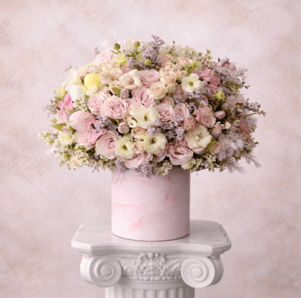Pastel bouquet of pink and white flowers in a pink cylindrical box