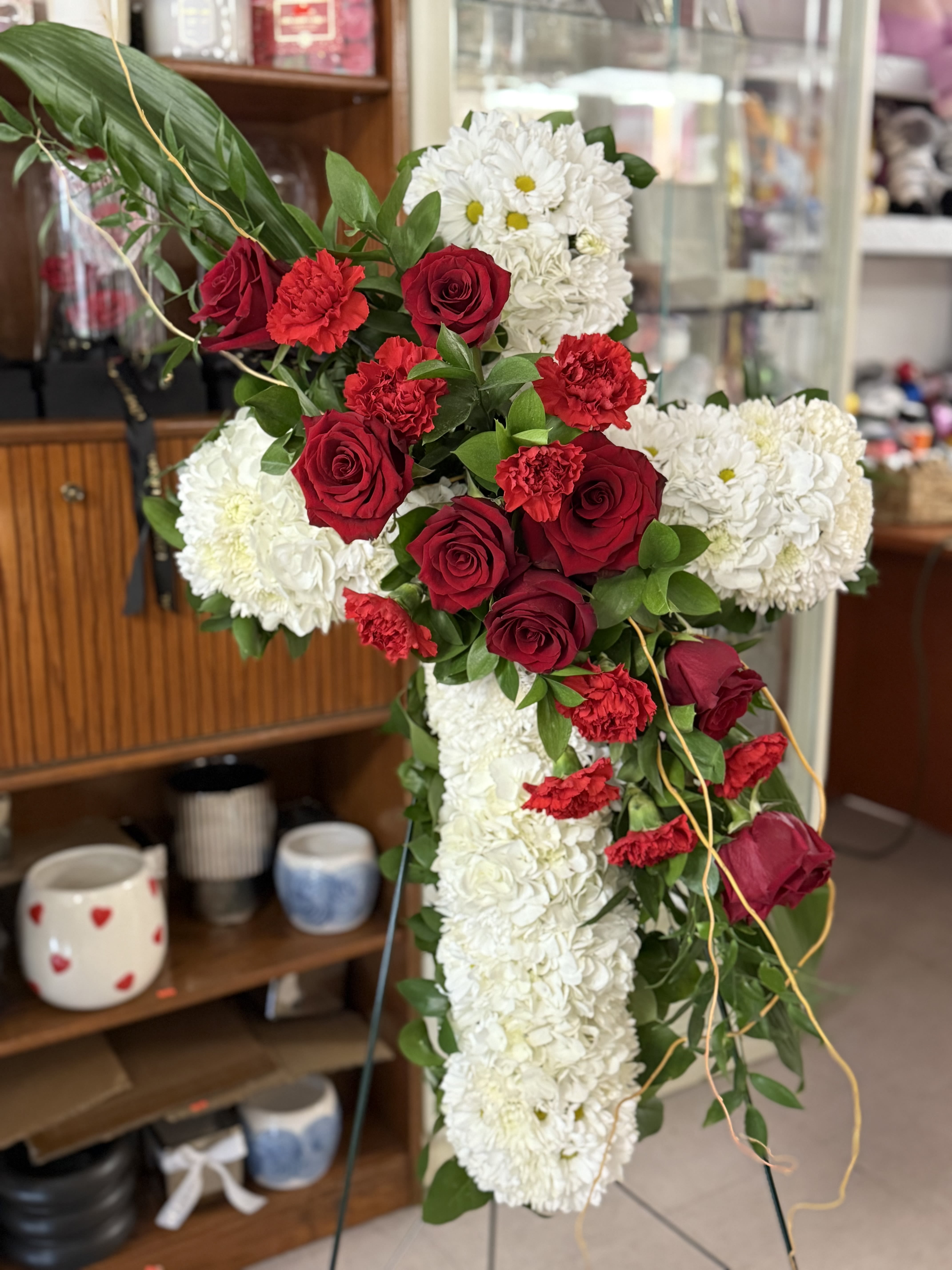 Cross-shaped floral arrangement with red roses and white chrysanthemums