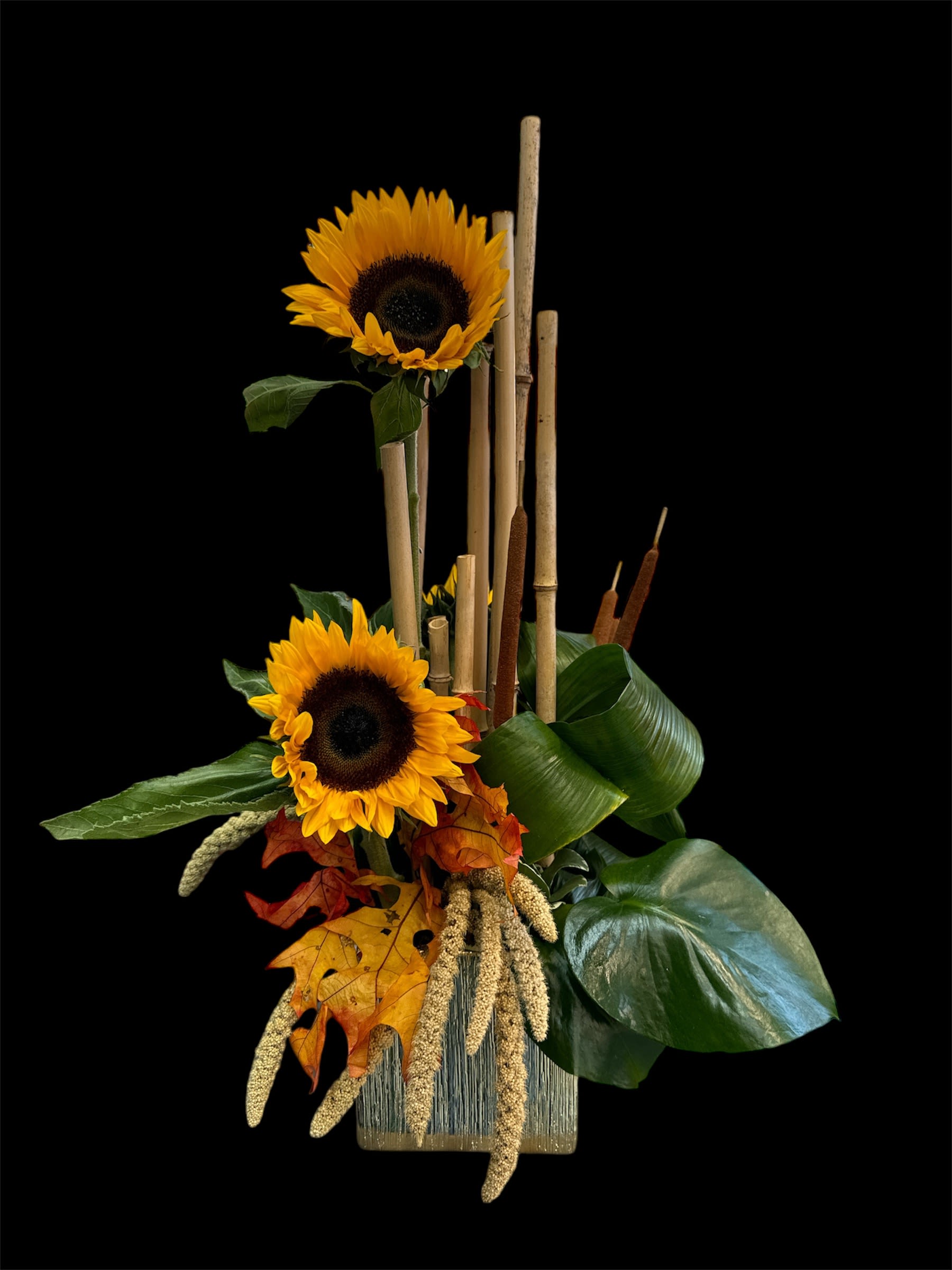 Sunflower arrangement with autumn leaves and bamboo sticks